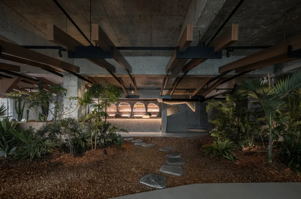 工業風餐廳室內,混凝土牆面、木樑與石材地板。