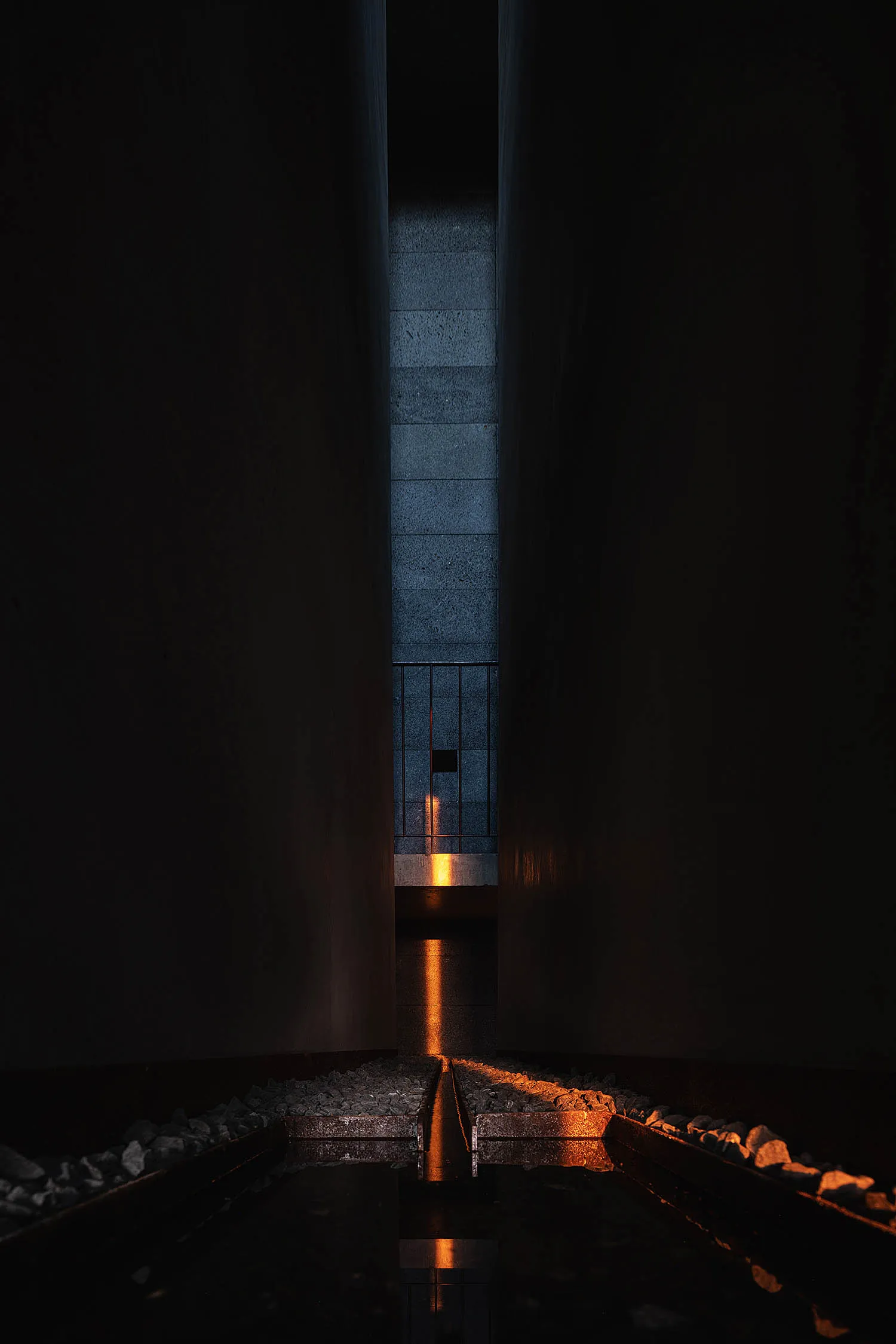 Minimalist interior space with concrete flooring and high contrast lighting effect.