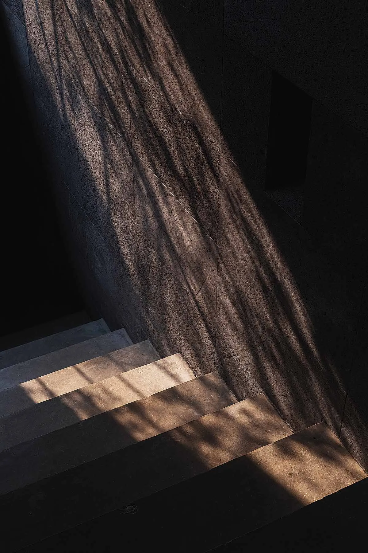 Modern concrete staircase with glass ombre lighting, showcasing contemporary design elements.