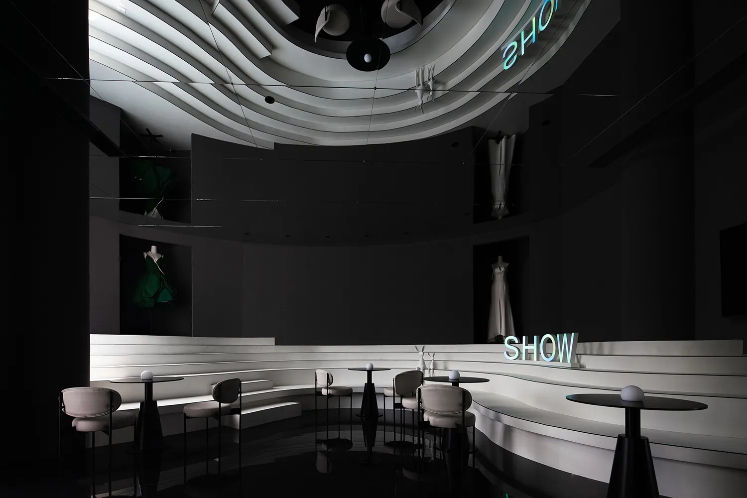 展示間內有混凝土平台、懸掛的綠色禮服,以及霓虹「SHOW」招牌。