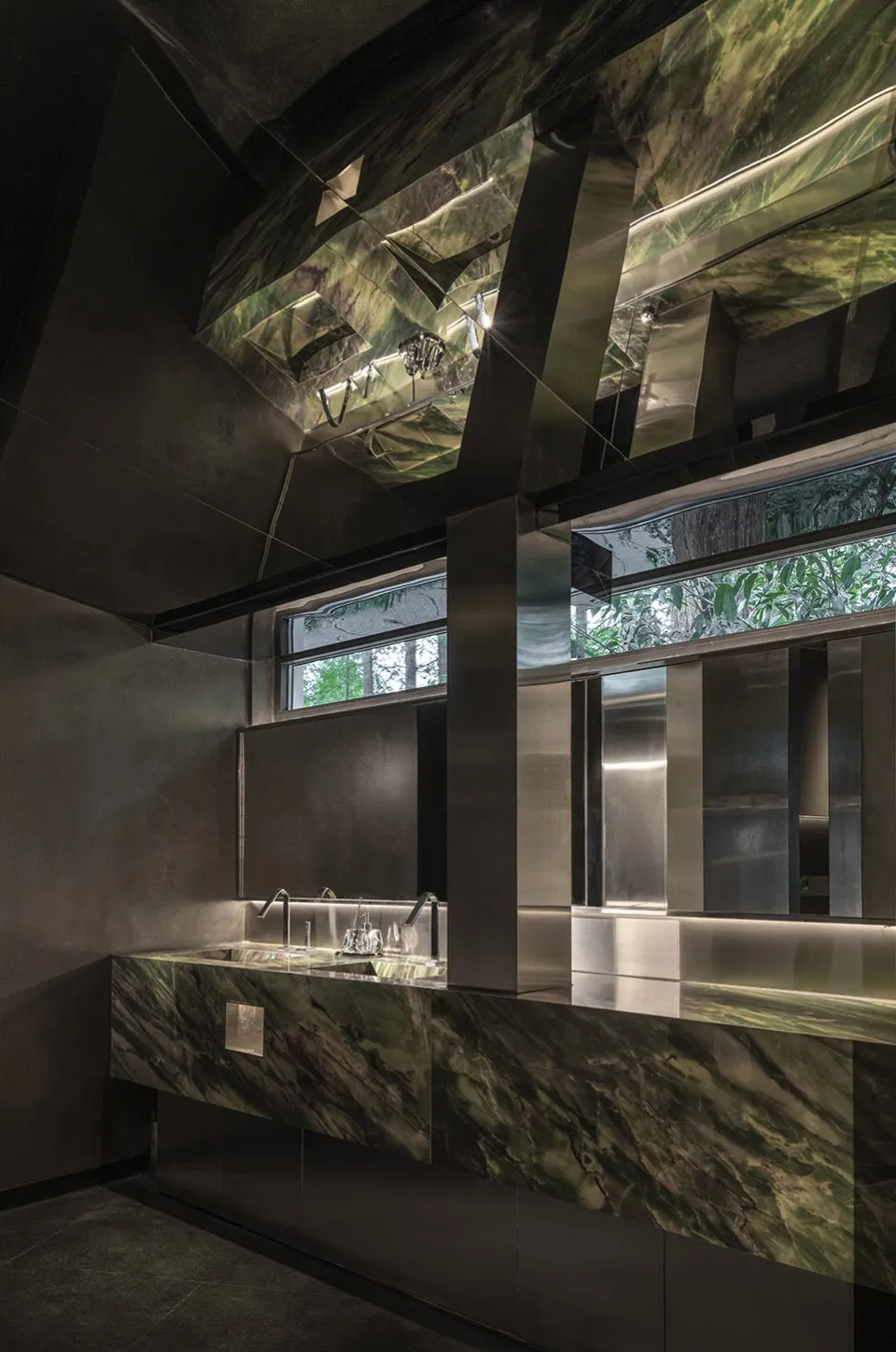 A modern bathroom featuring marble materials and dark lighting.