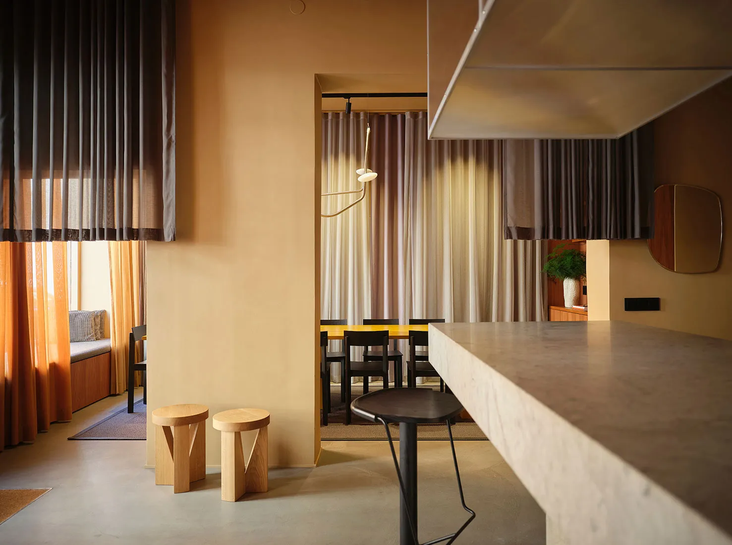 Modern living room with concrete furniture, ambient lighting, and warm tones.