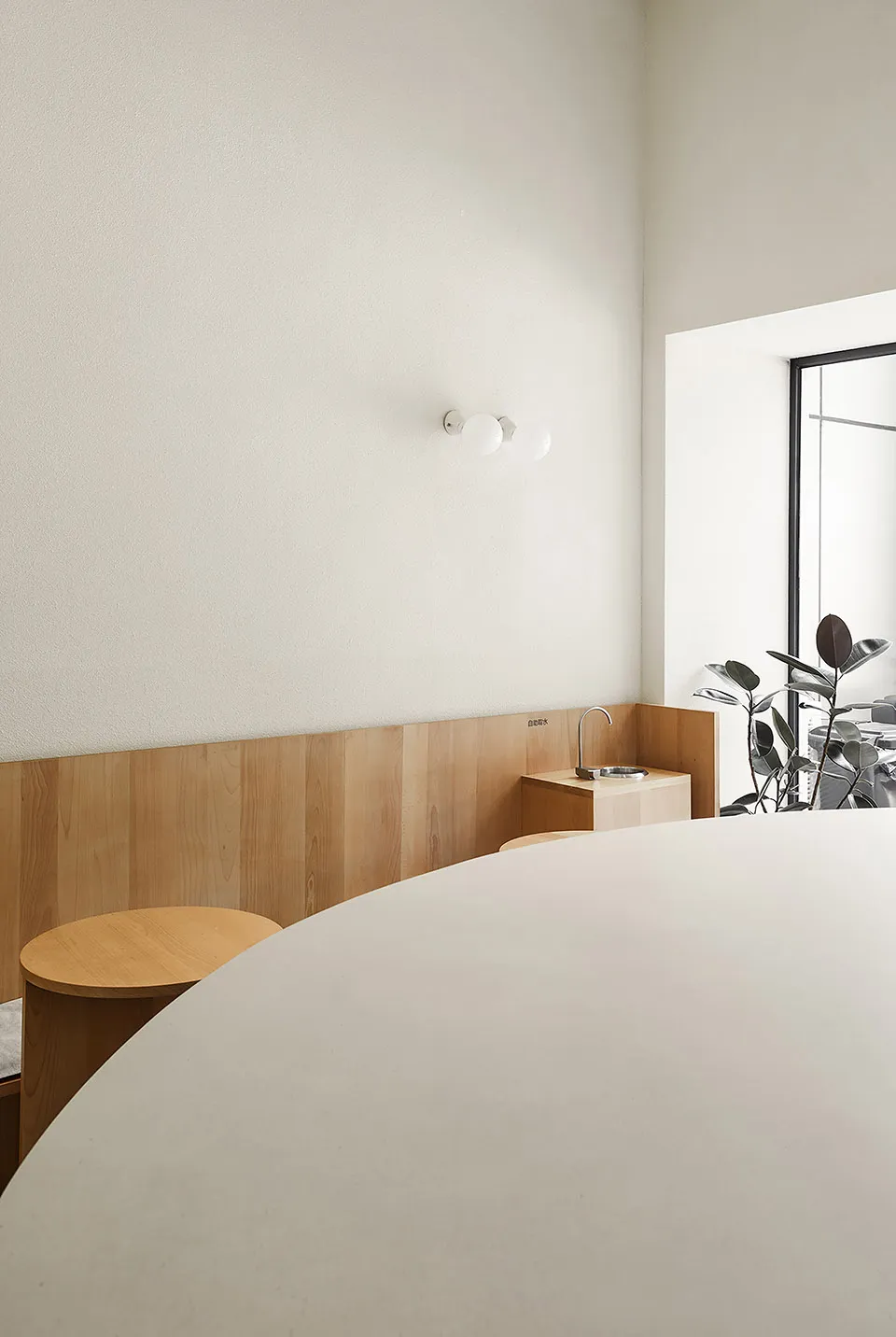 Minimalist café interior featuring wooden surfaces and concrete elements.