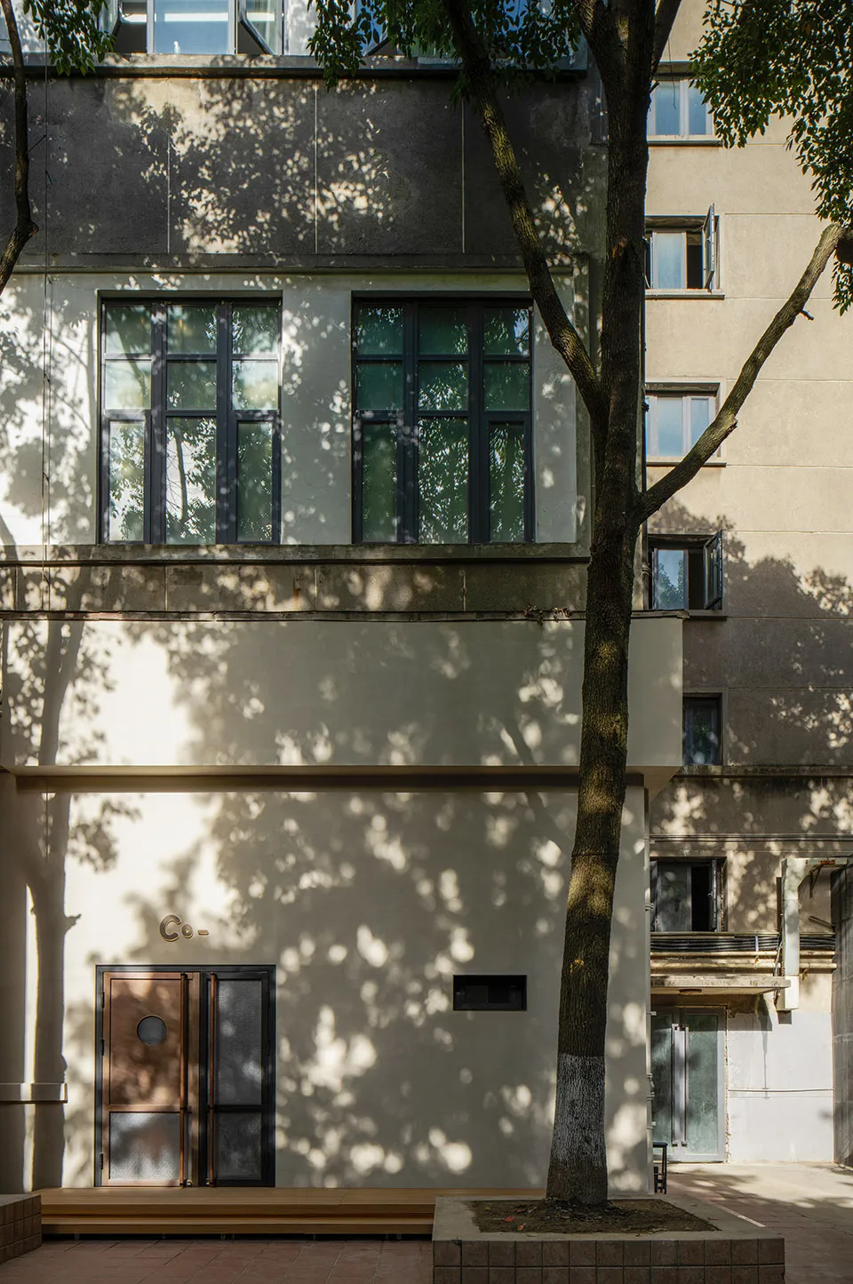 A modern architectural interior featuring a concrete facade and large windows.