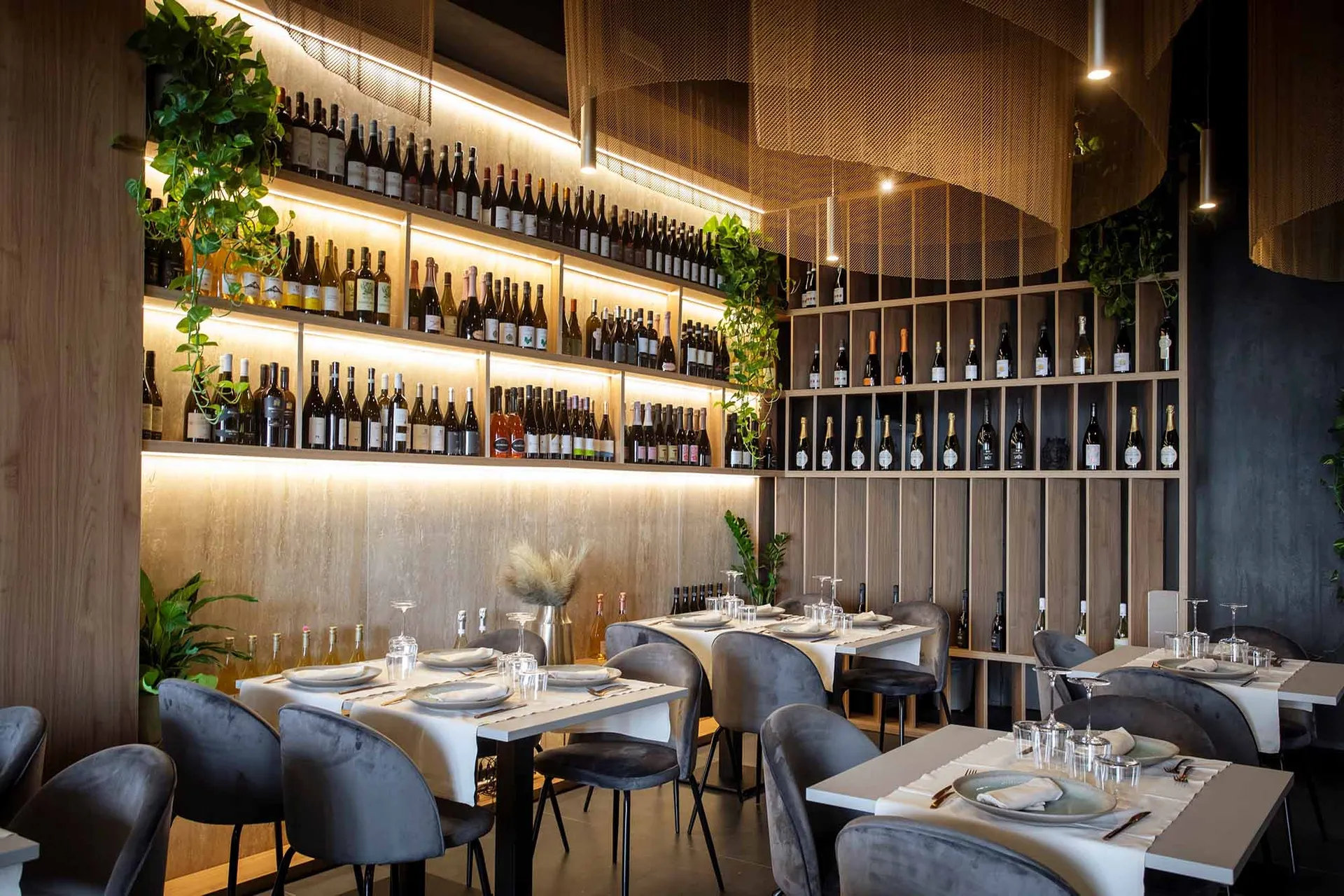 A stylish modern wine bar with wooden accents and a variety of bottles on shelves.