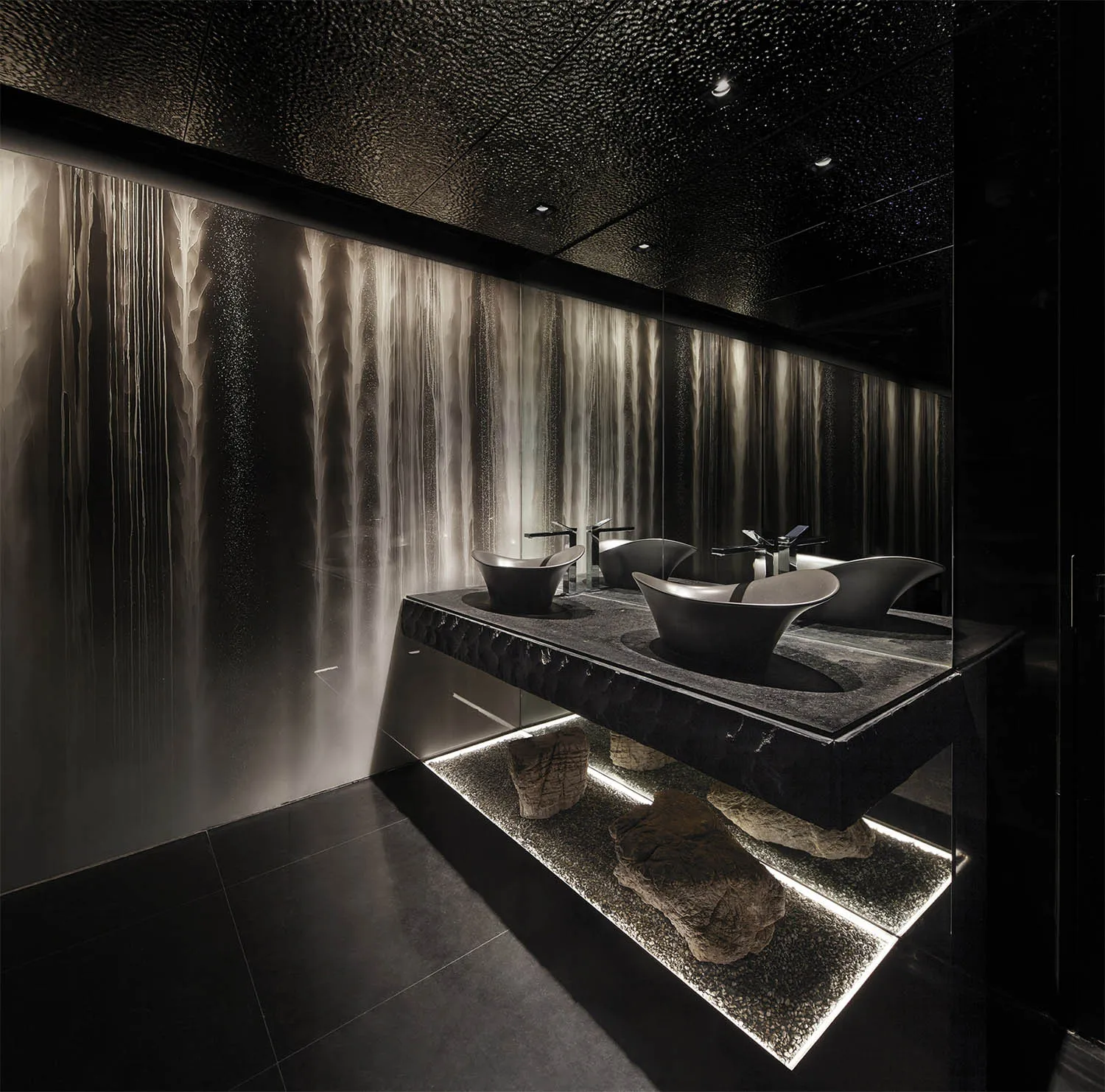 A modern bathroom with glass and stone materials.