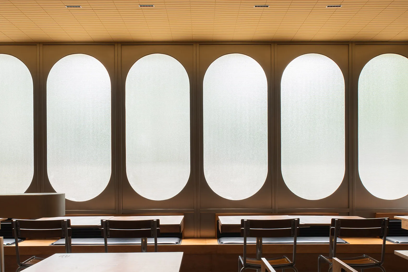 A modern classroom featuring oval-shaped windows made of frosted glass.