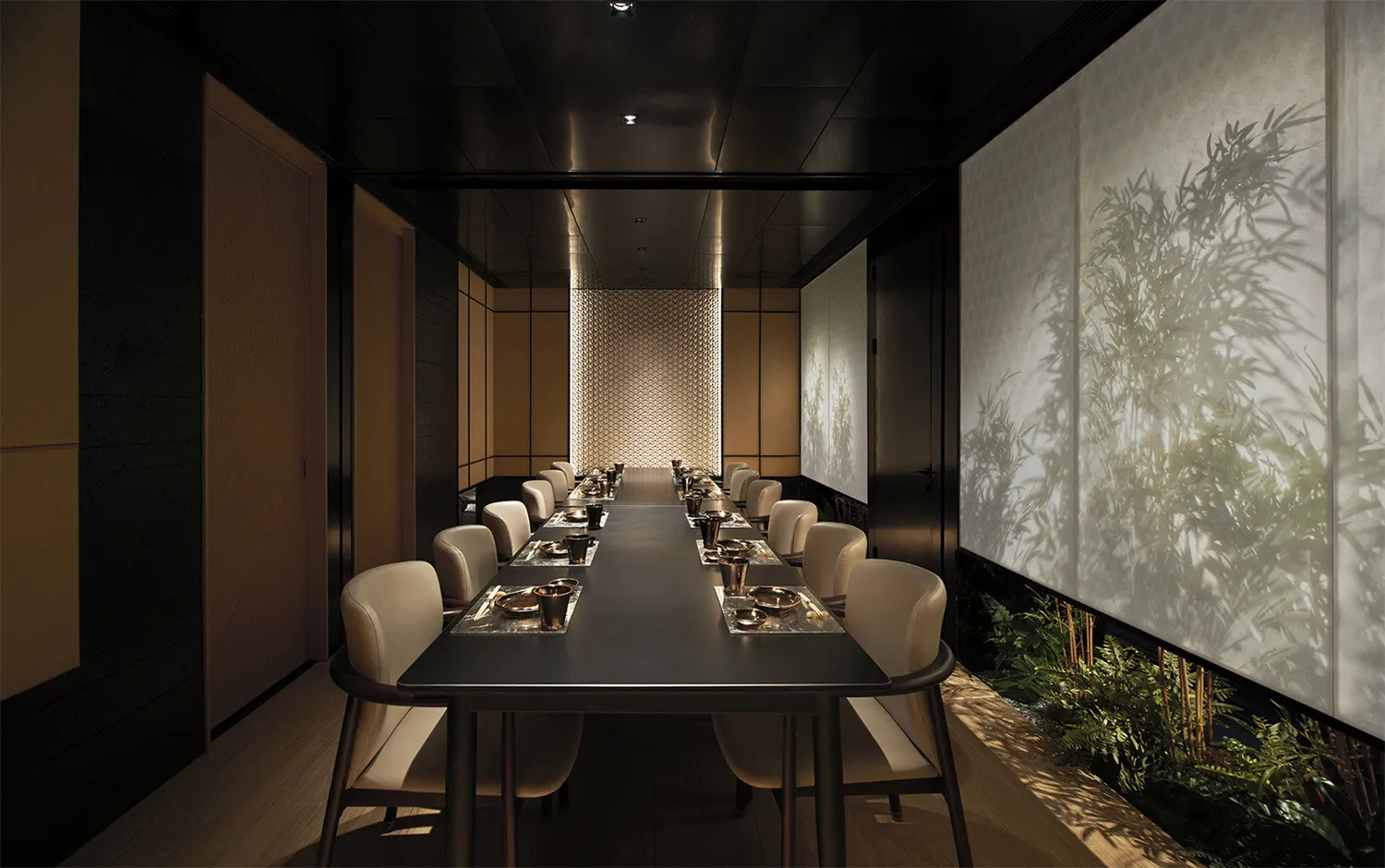 A sleek, modern dining room features a long, black dining table surrounded by plush, cream-colored chairs under a dark, minim