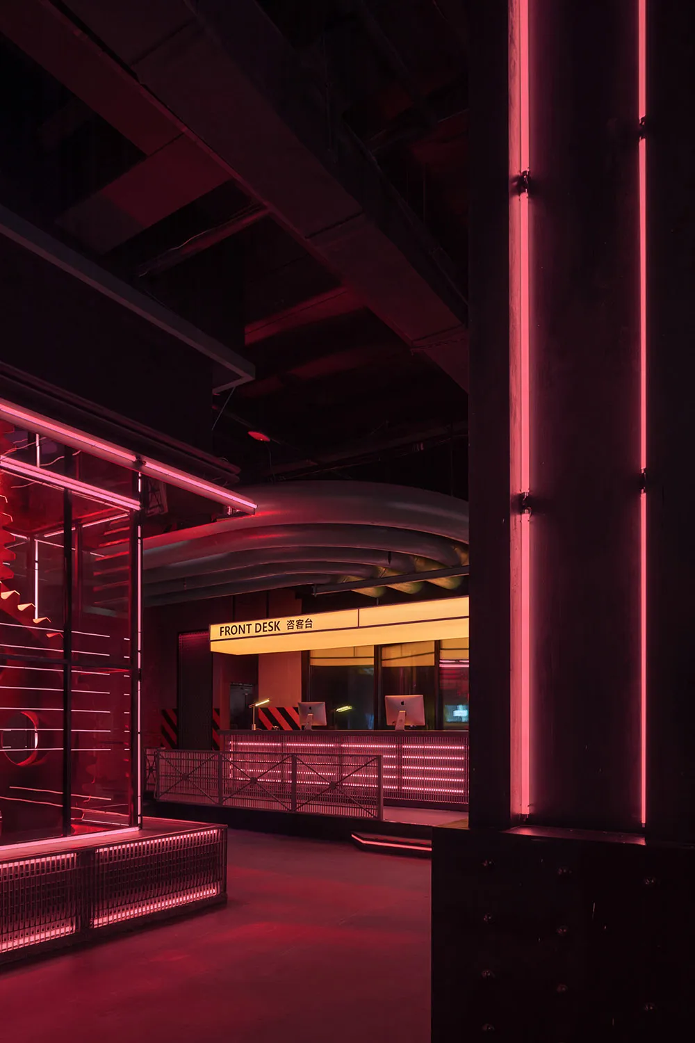 Modern industrial lobby interior with metallic accents and red neon lighting.