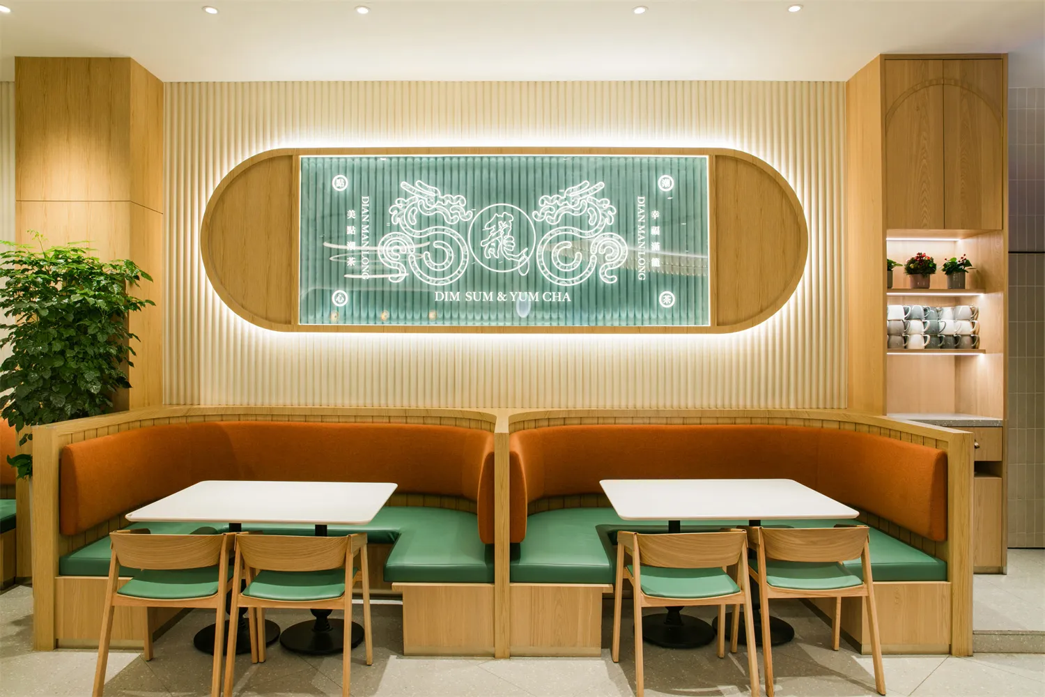 A modern industrial restaurant interior featuring wooden furniture and paneling, white tables, green seat cushions, and a gre