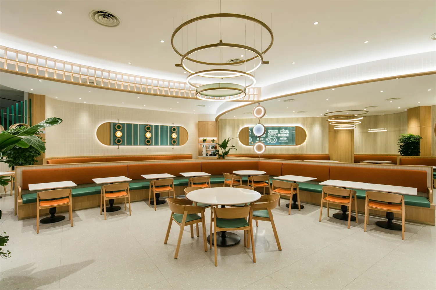 Modern restaurant interior featuring orange fabric seating and wooden furniture.