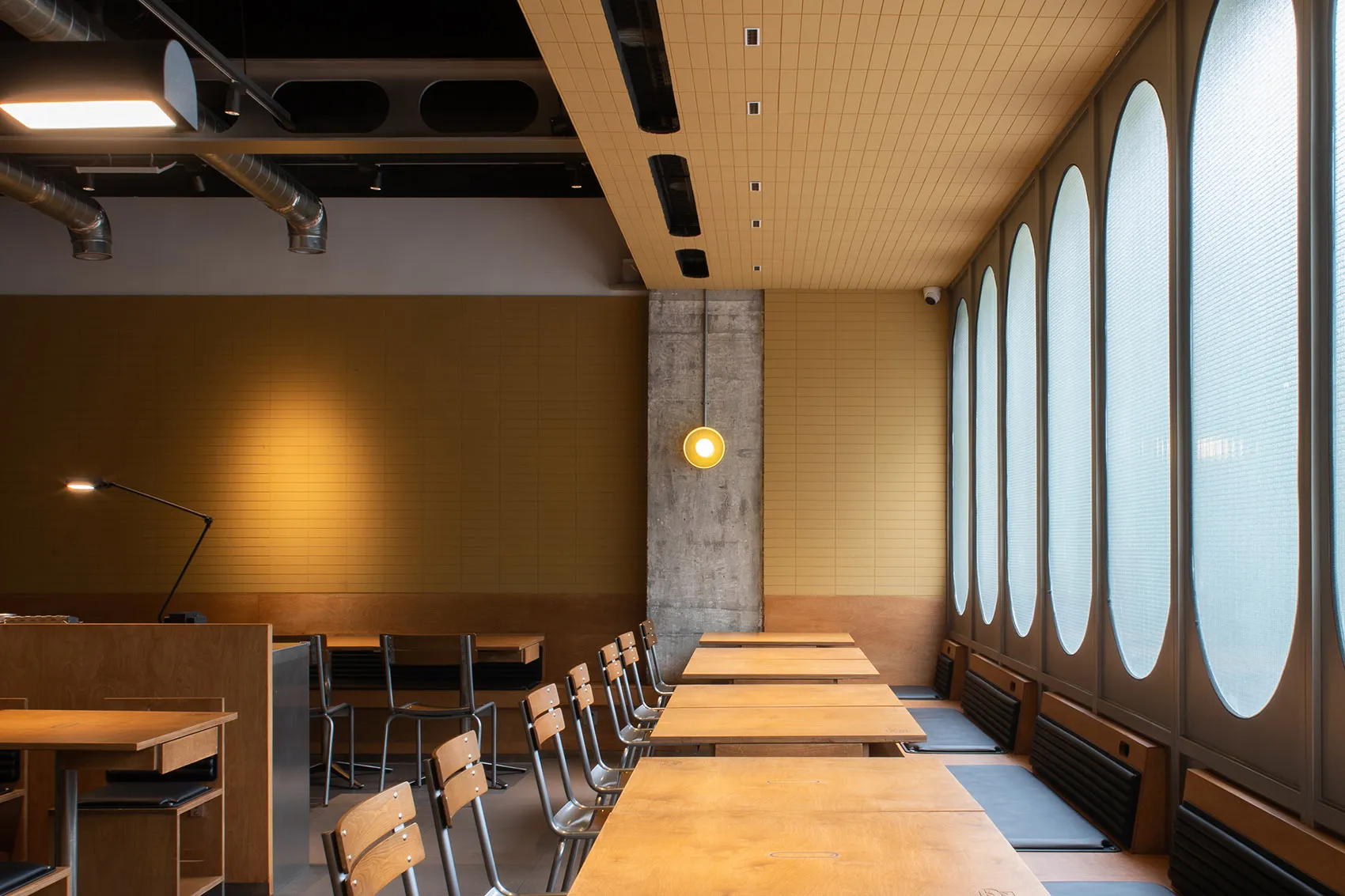 現代餐廳室內,搭配木質餐桌、混凝土牆面與玻璃窗