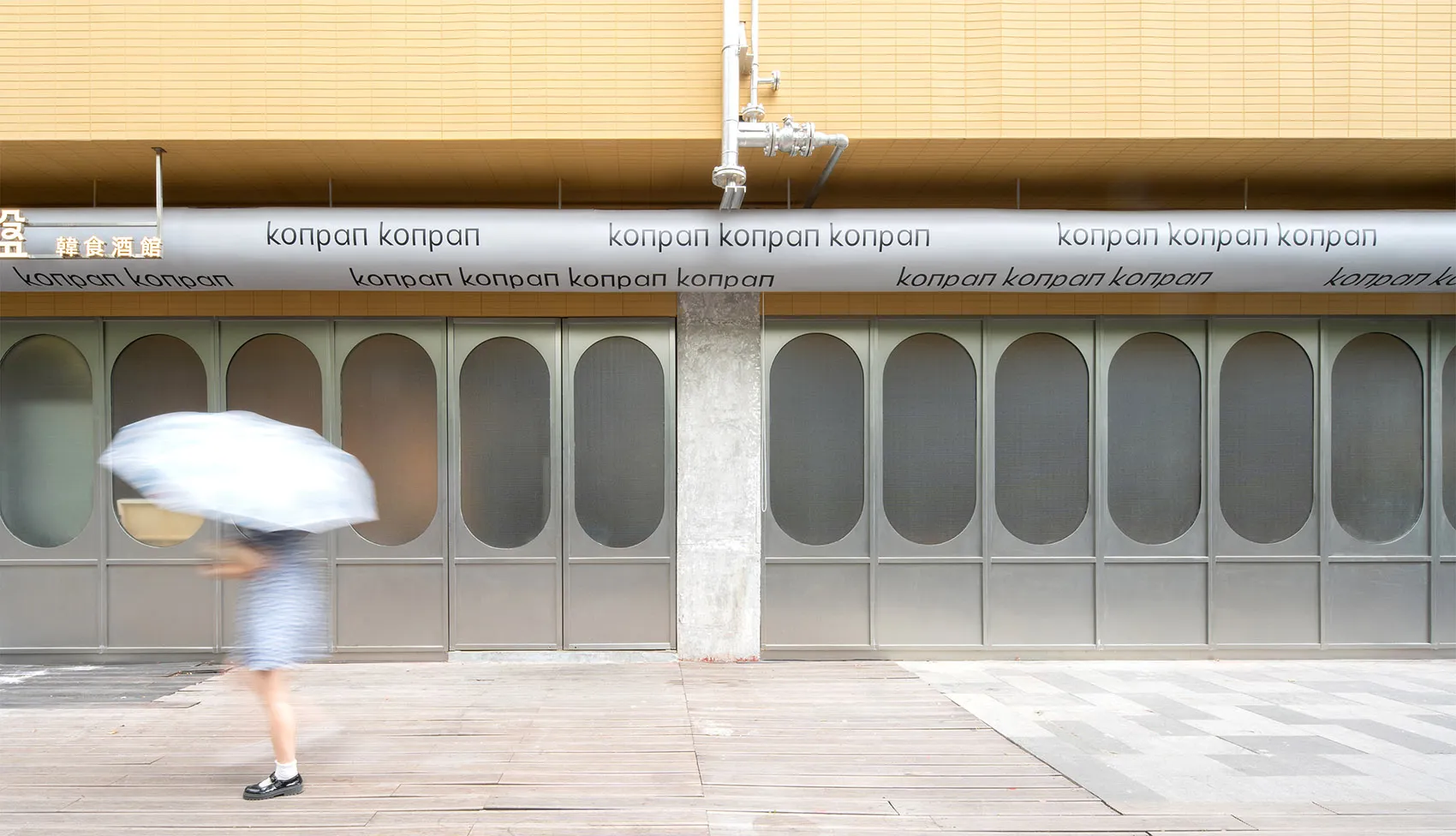 A modern building facade with metallic elements in an urban setting.