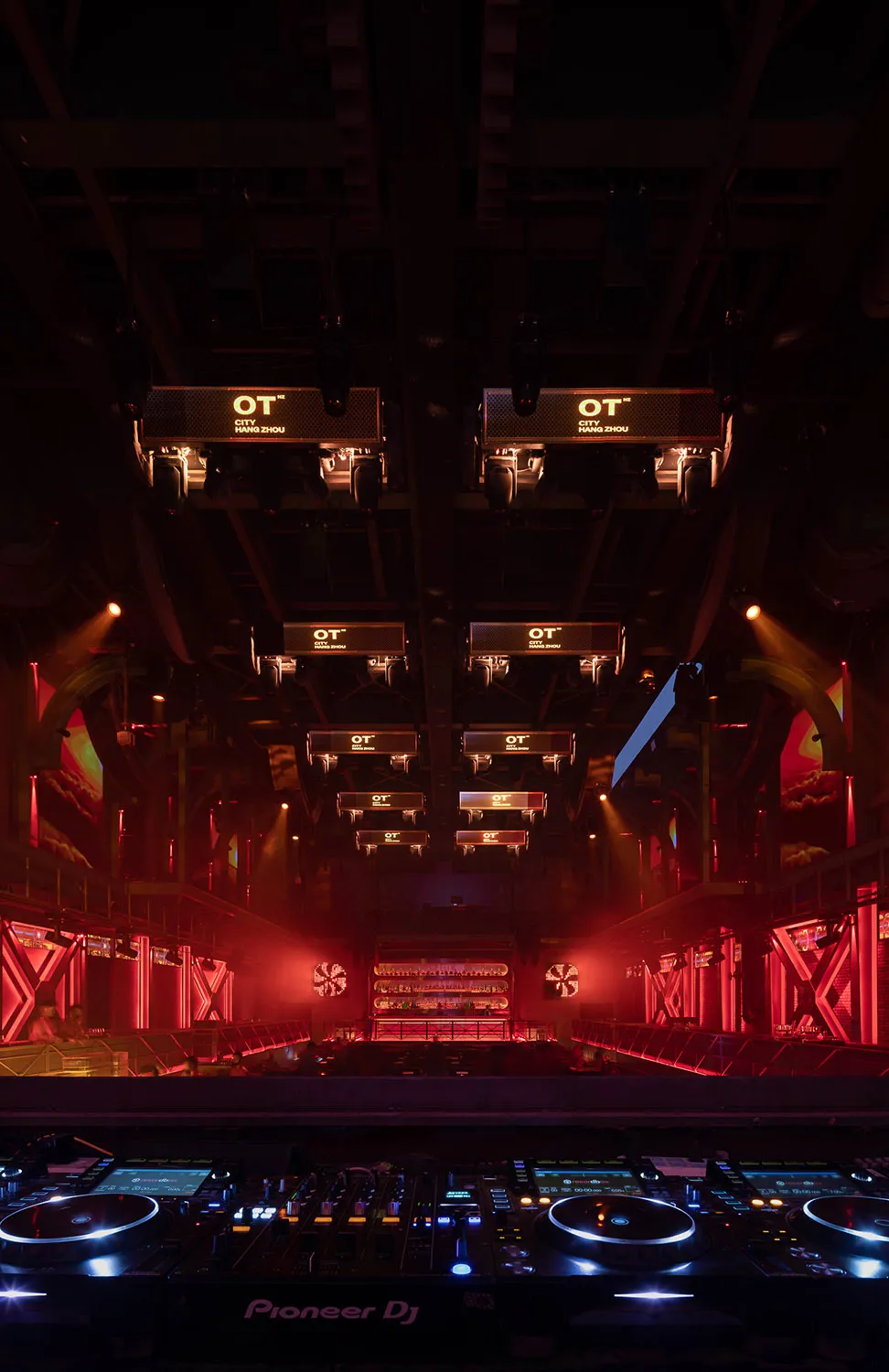 An illuminated nightclub interior featuring metal and glass architectural elements.