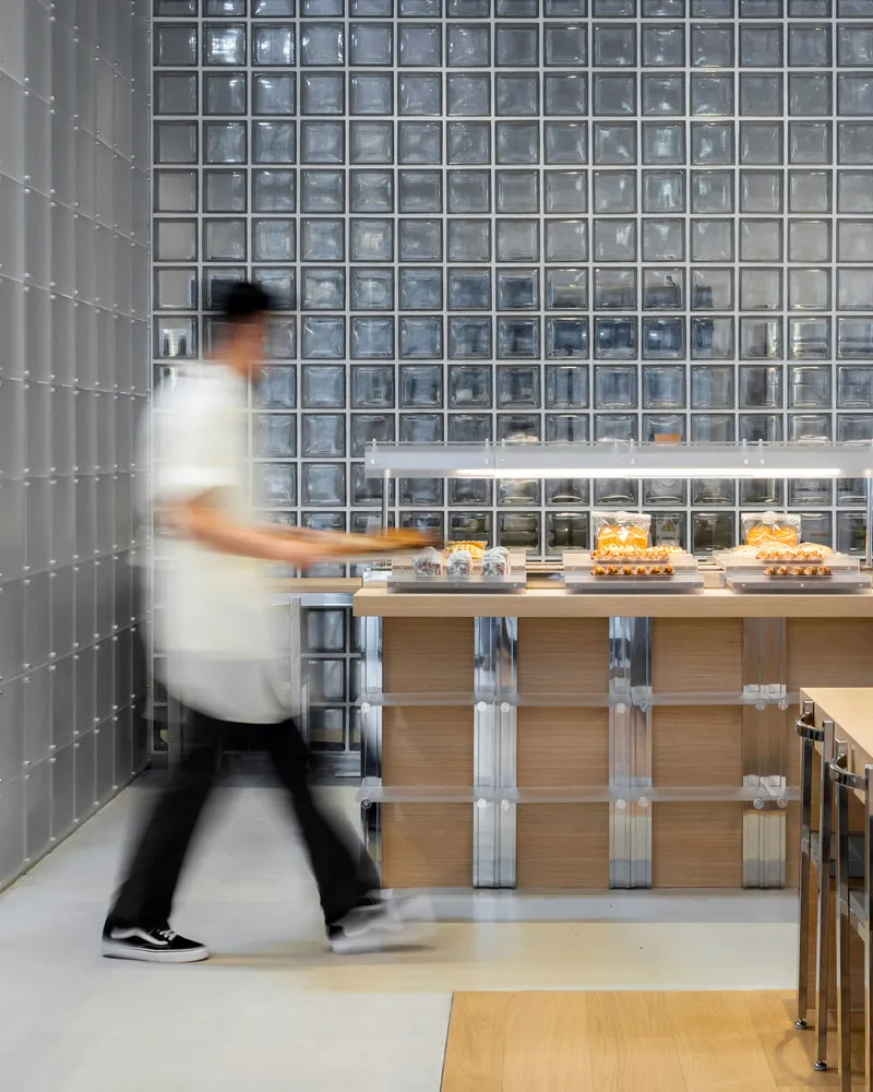A modern restaurant interior features glass block walls and loft wood accents