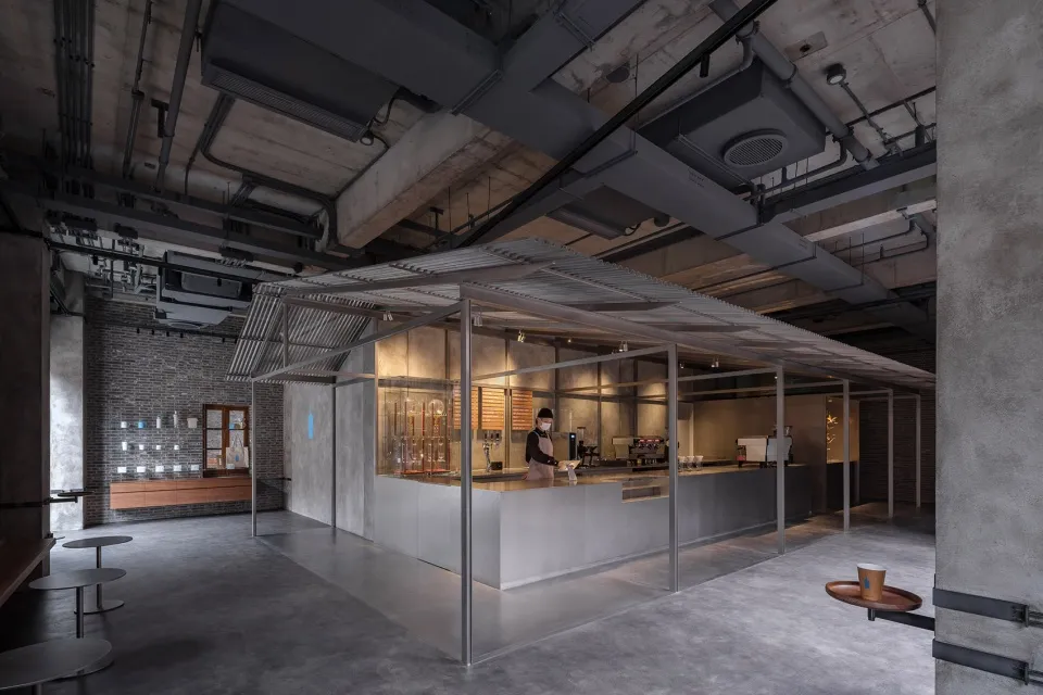 現代工業風咖啡店採用極簡設計,中央設有混凝土吧台與金屬板材。