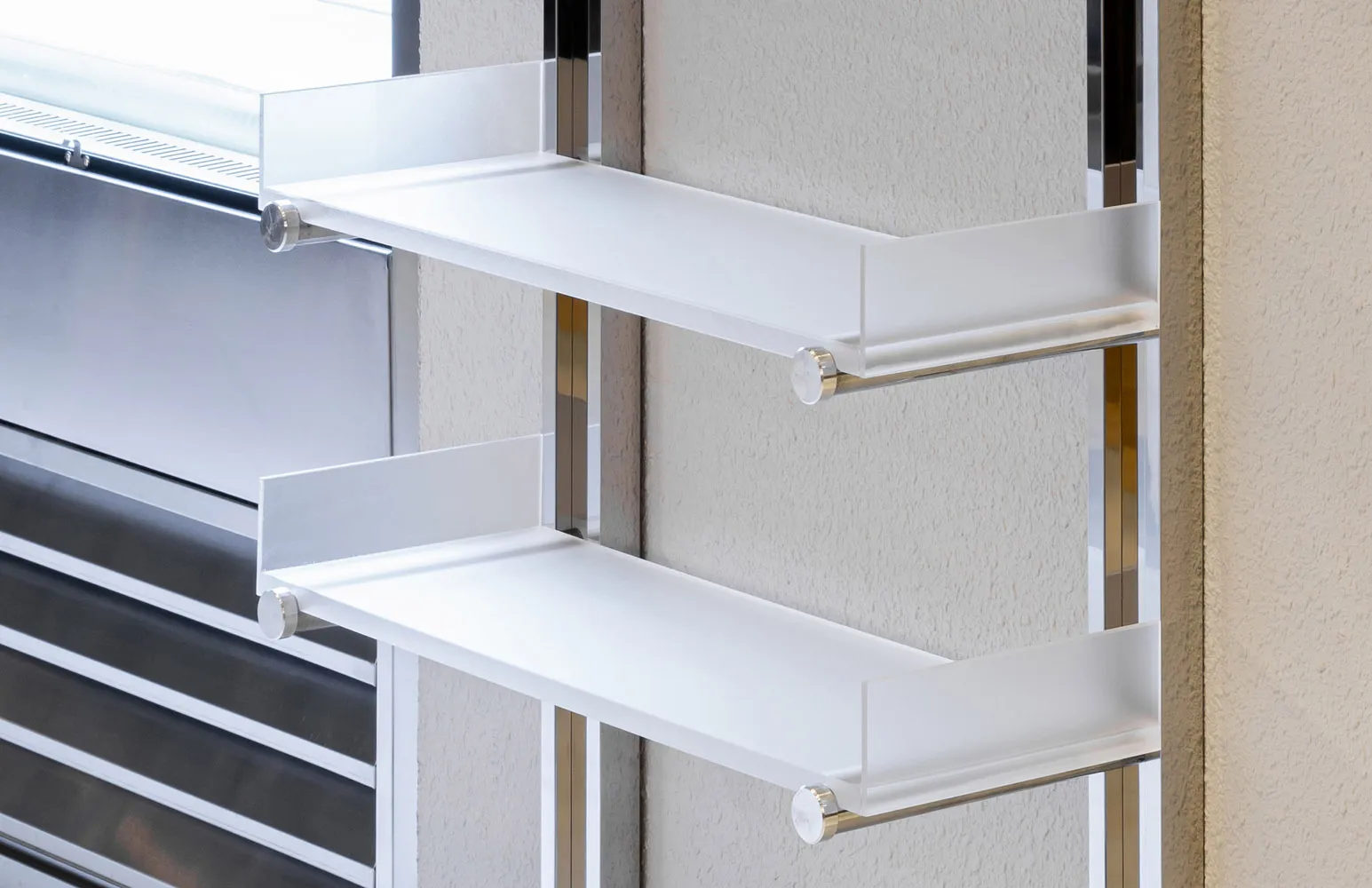 Modern interior design featuring metal and acrylic floating shelves against a textured wall