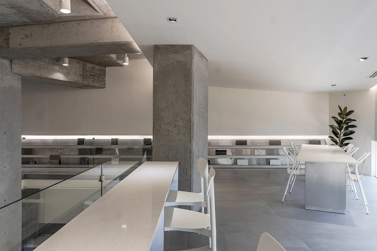 A modern office space with concrete walls and glass furnishings