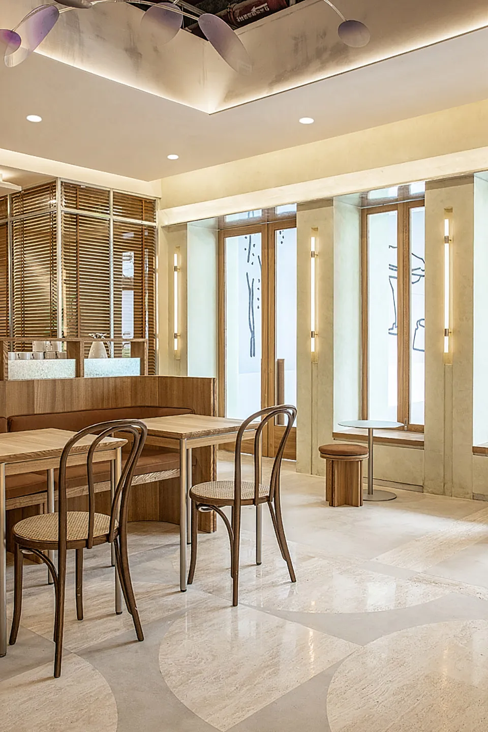 Modern cafe restaurant interior with wood furniture, glass walls, and marble floor.