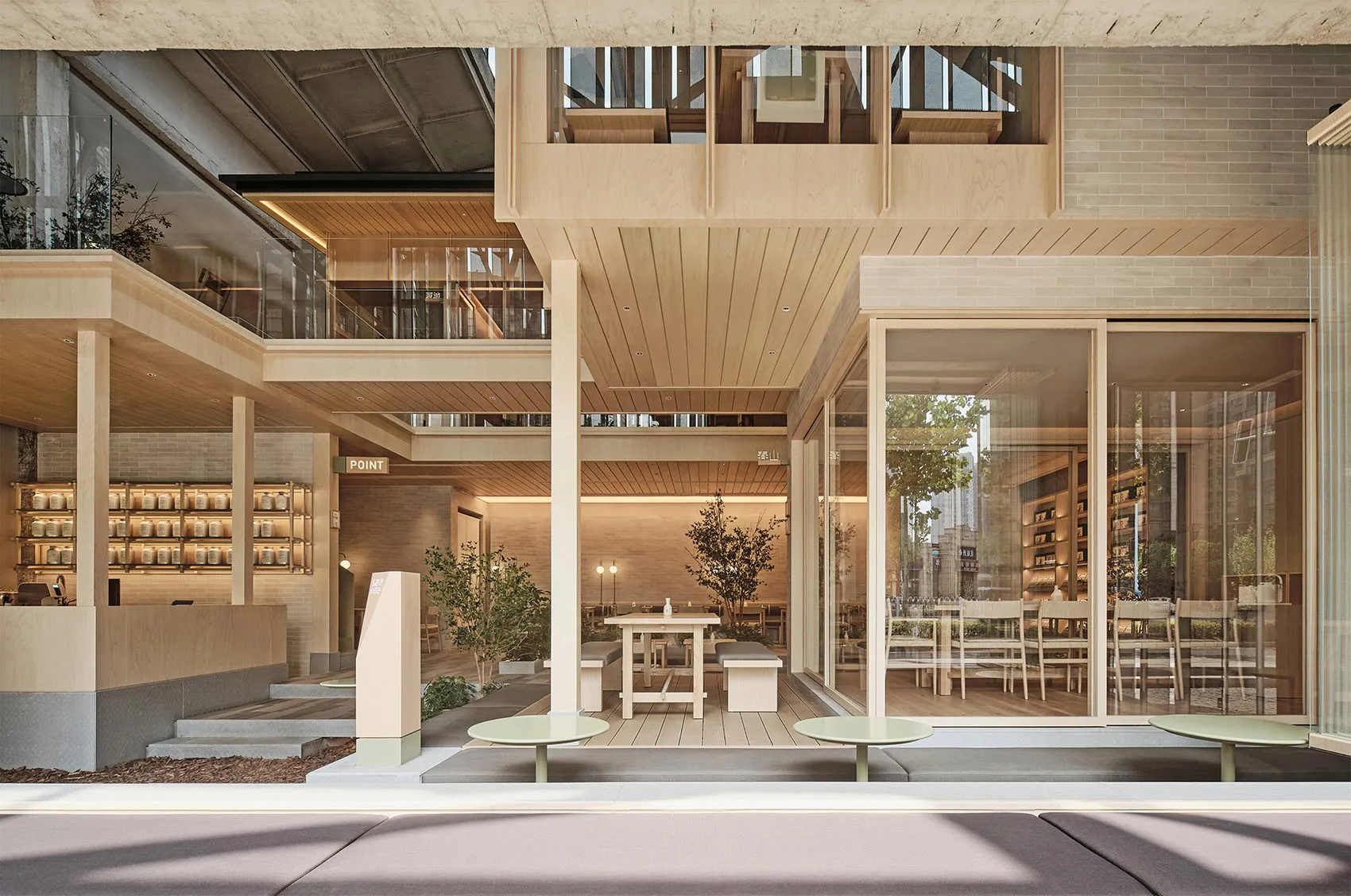 A modern restaurant interior featuring wood, concrete, and brick materials and a multi-level design.
