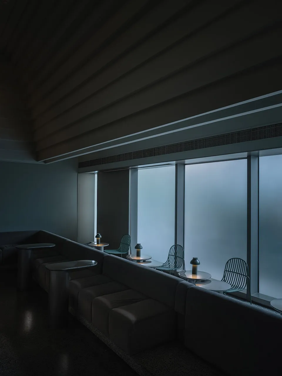 簡約餐廳室內,配有金屬家具與大型玻璃窗。