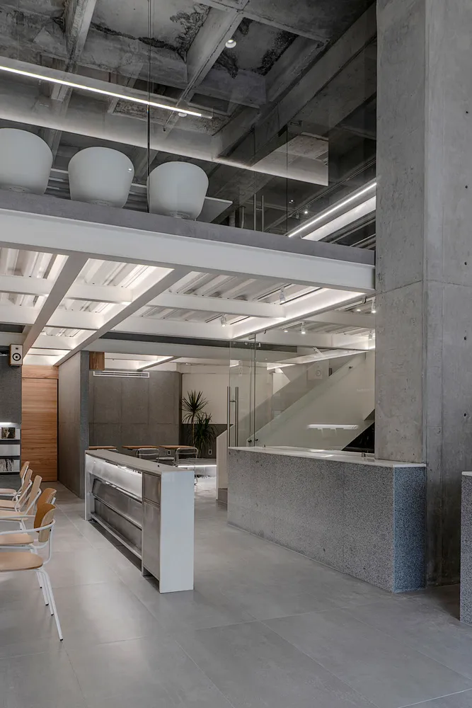 Industrial-style office space featuring concrete, glass, and metal materials.