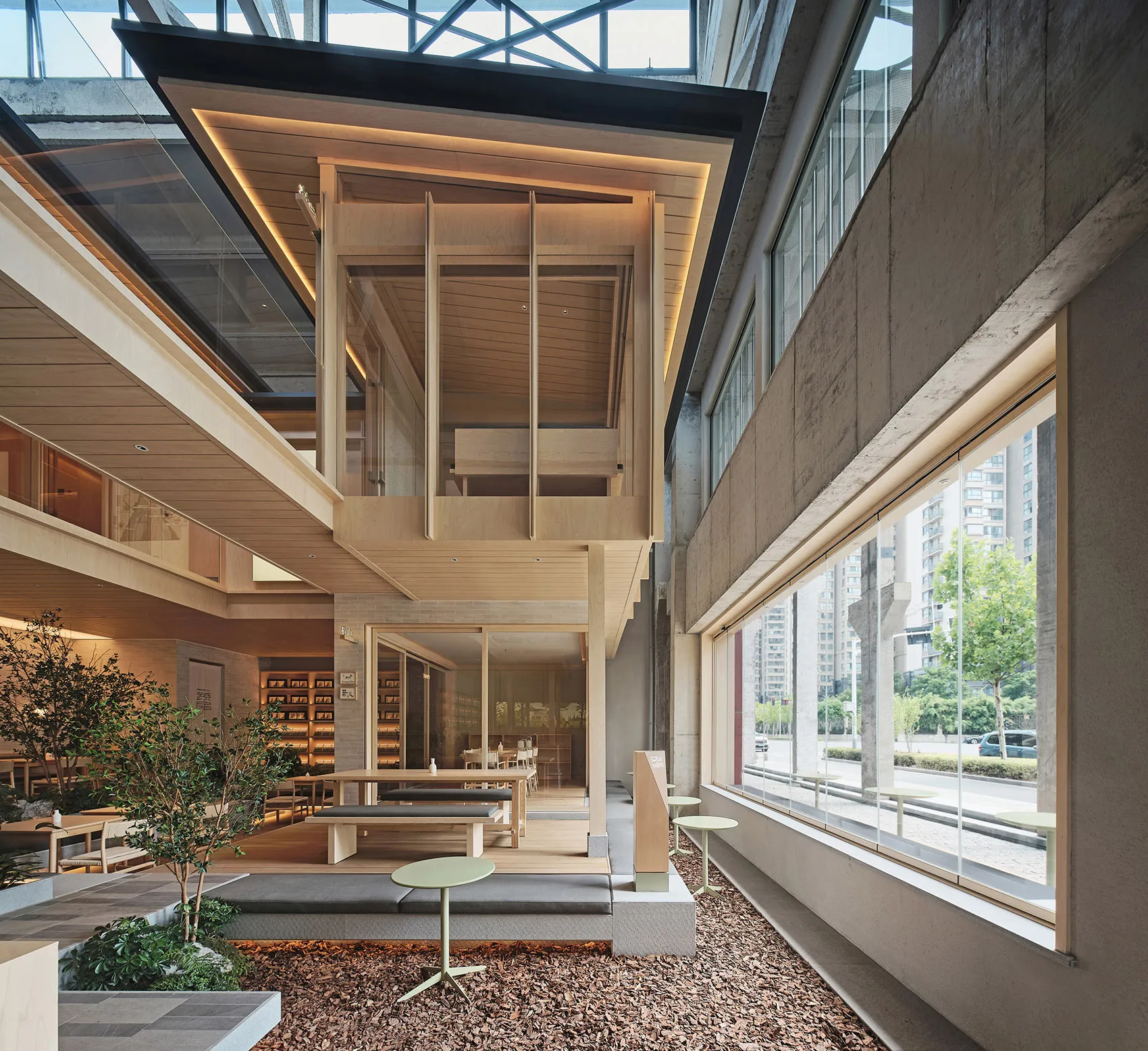 Modern interior space with wooden structures, glass walls, and concrete elements.