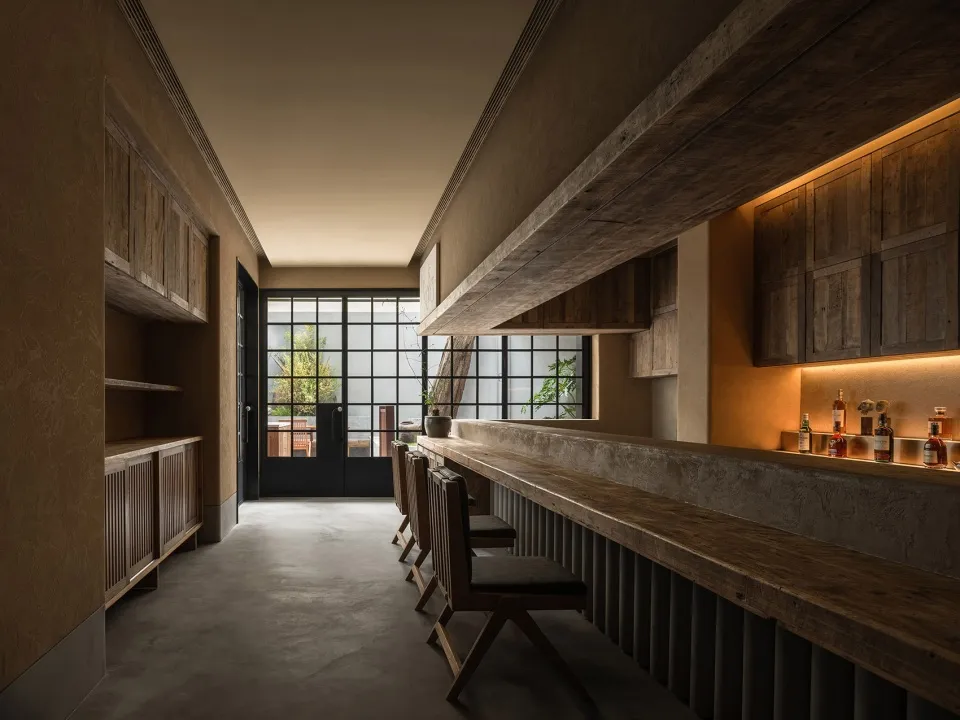 A wooden and concrete industrial-style bar with concrete floor and industrial-style cabinets.