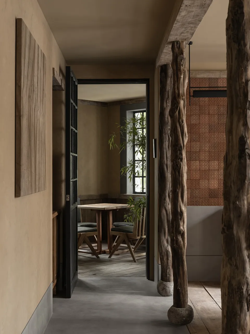 Industrial-themed restaurant interior with wooden tables, concrete flooring, and terracotta tiles.