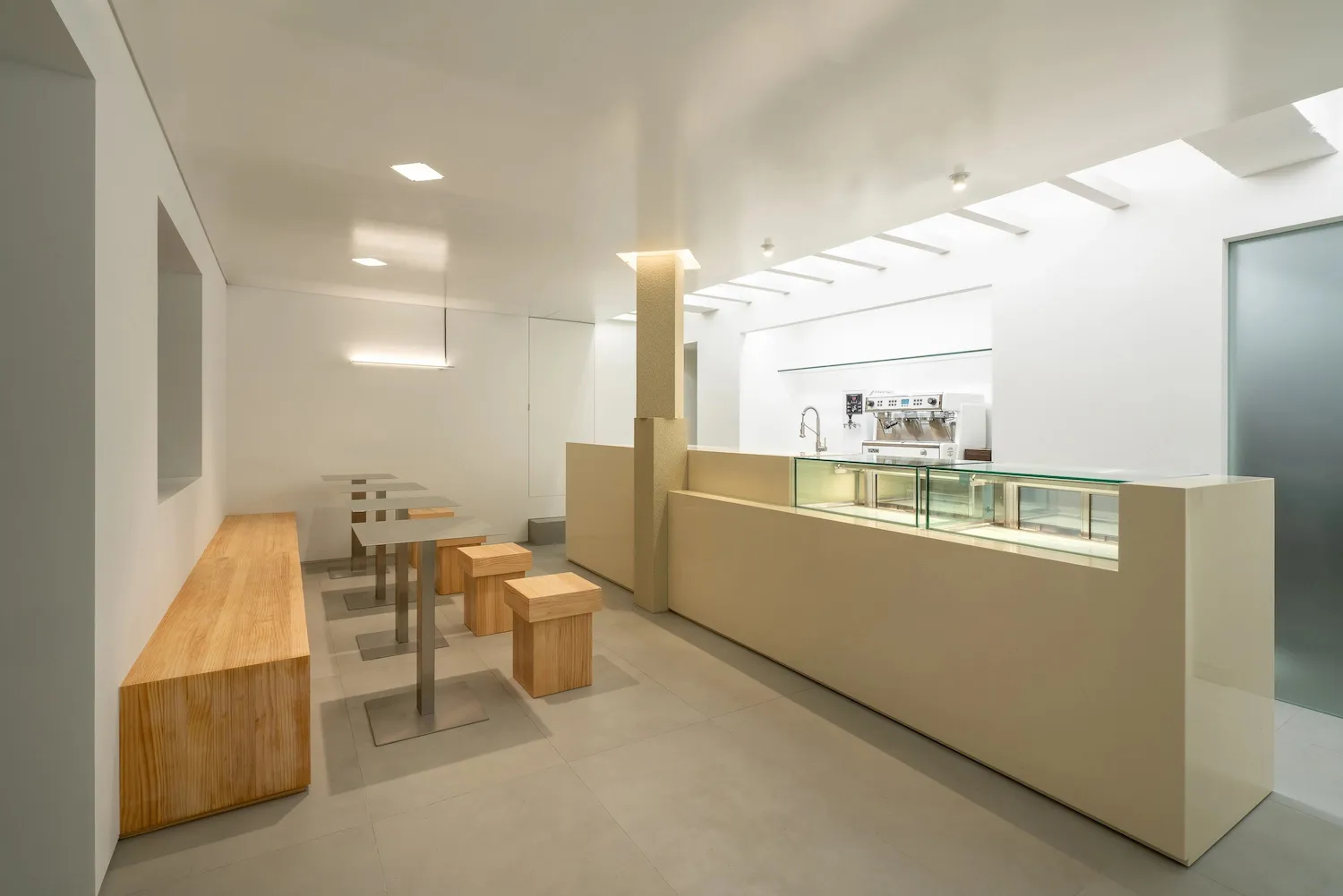 Modern cafe interior with white walls, minimalist styling, and bright lighting