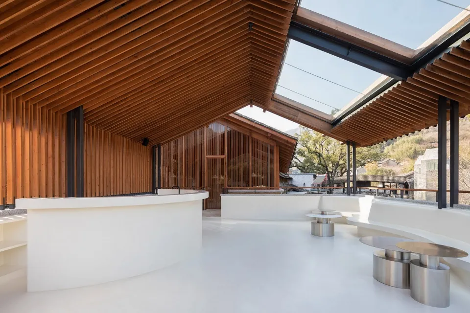 Modern coffee shop featuring wooden beams and a glass-covered deck.