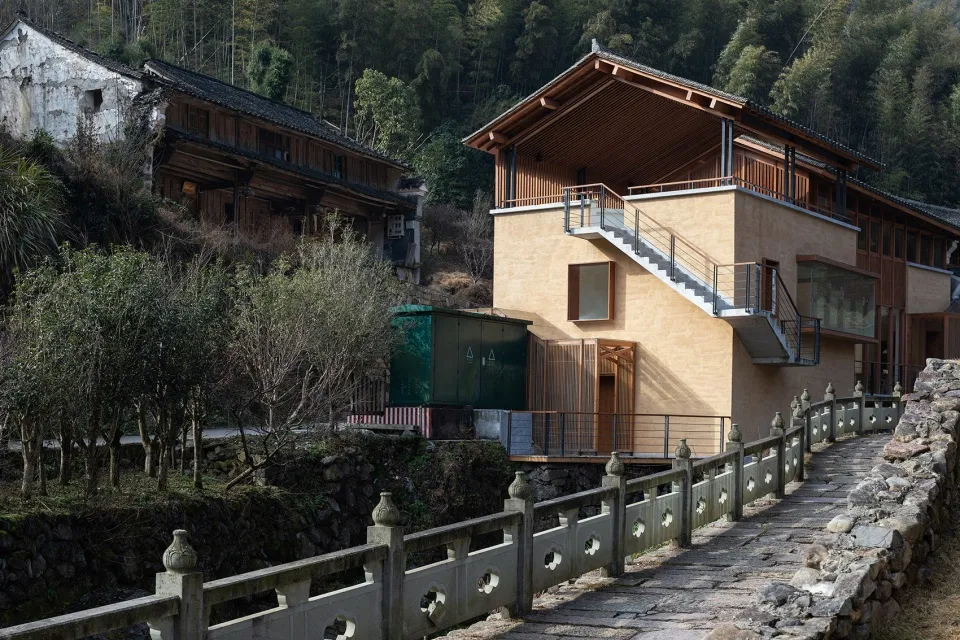 A modern residential wooden home with a sloped roof and stone walkway.