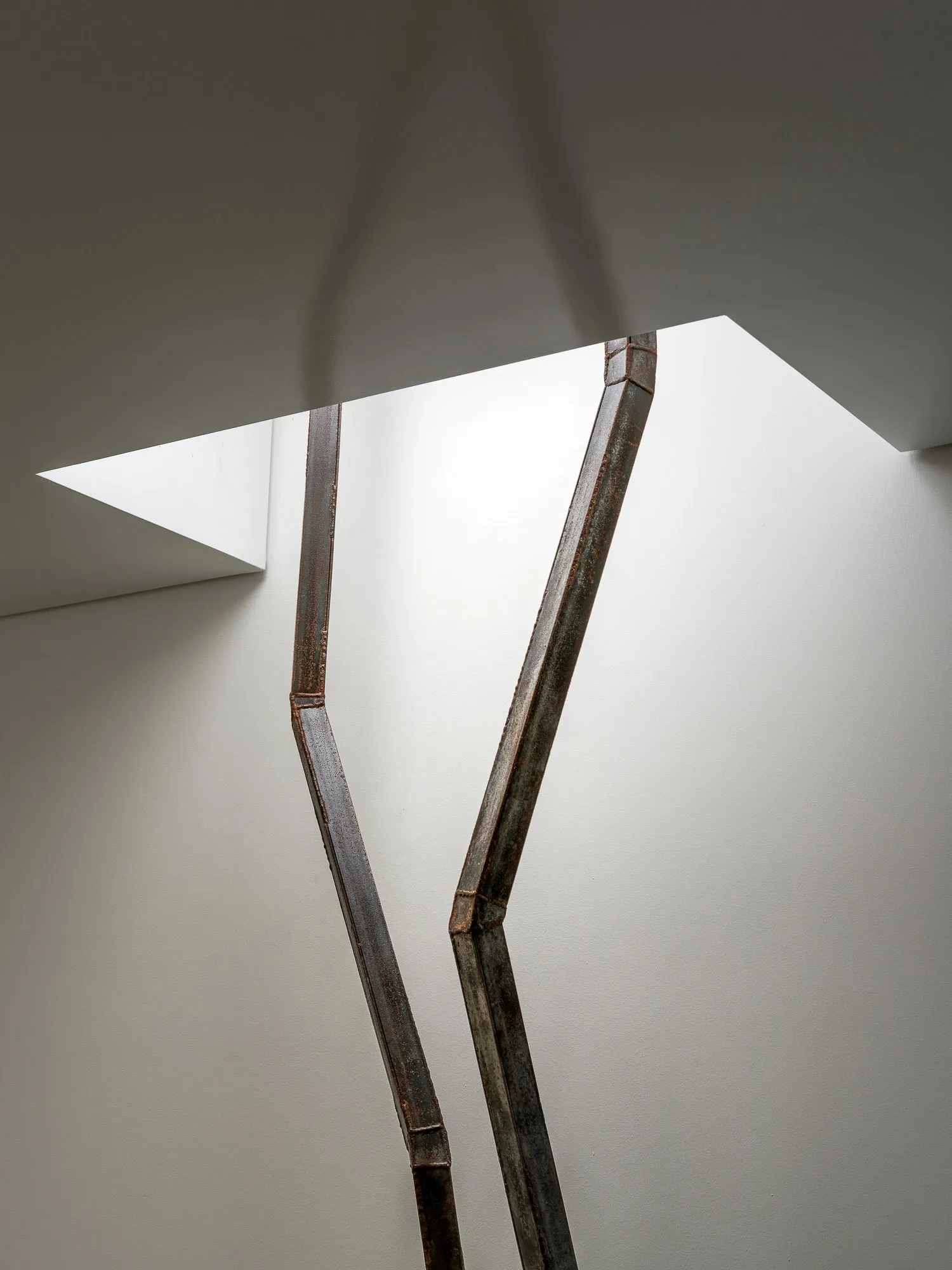 A modern, industrial-style lighting fixture made of metal.