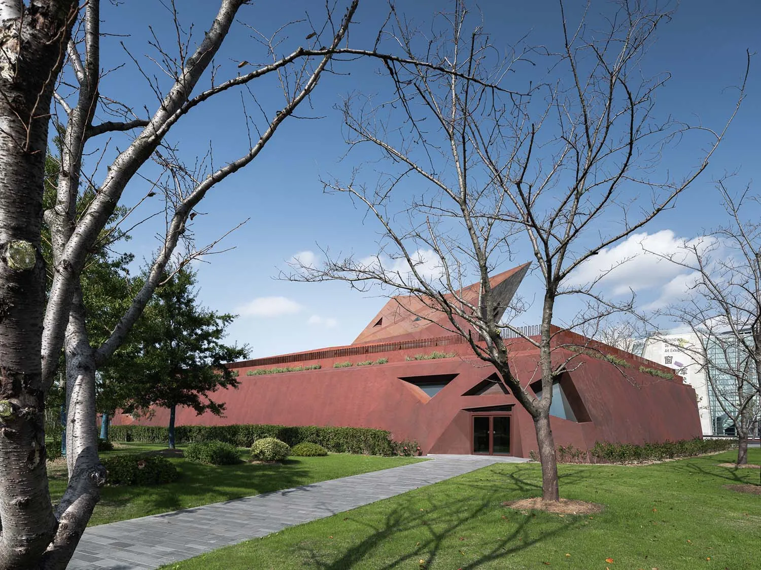 紅色金屬建築搭配幾何設計與綠色草坪