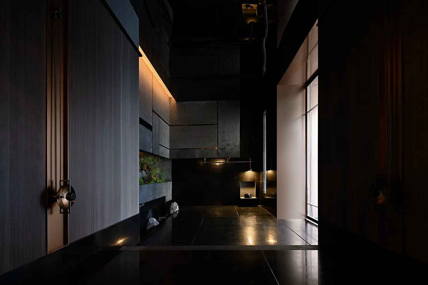 Modern, minimalist entry-way featuring concrete surfaces and a sleek, dark design.