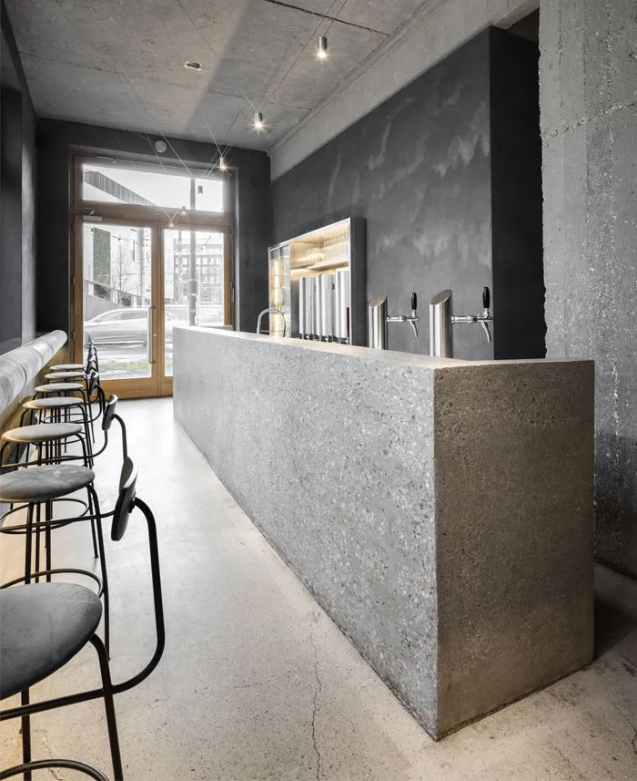 Industrial-style bar counter with concrete finish and stools