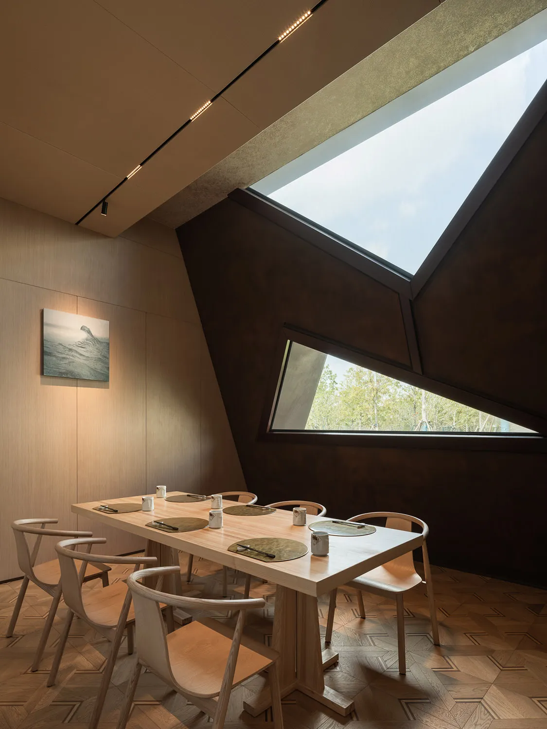A modern dining room with wooden furniture and large windows.