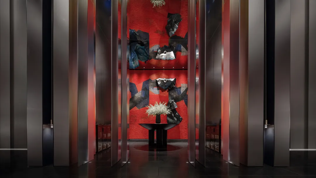 A modern hotel lobby featuring metallic texture floors and walls.