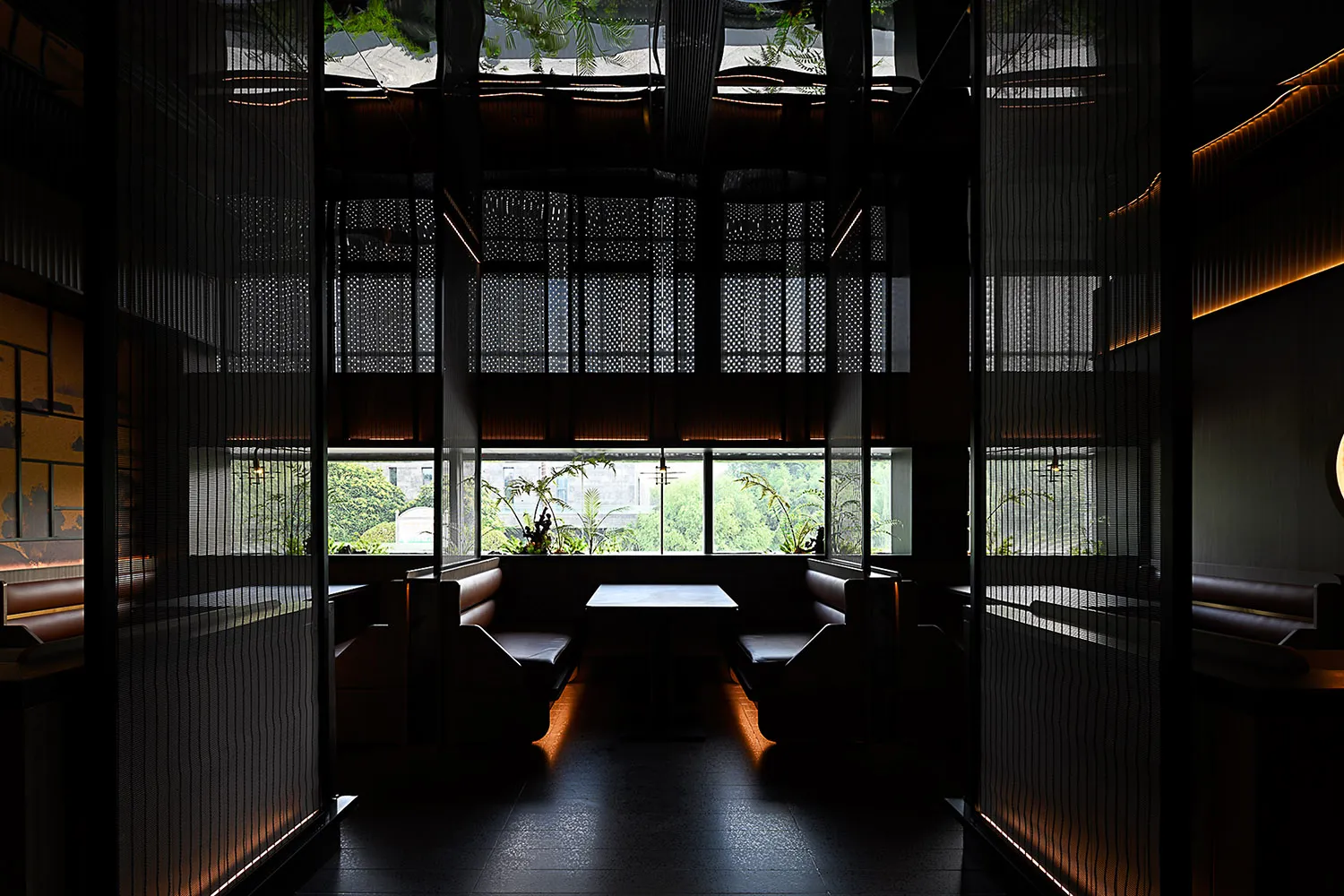 A modern restaurant interior featuring comfortable leather seating and glass paneling.