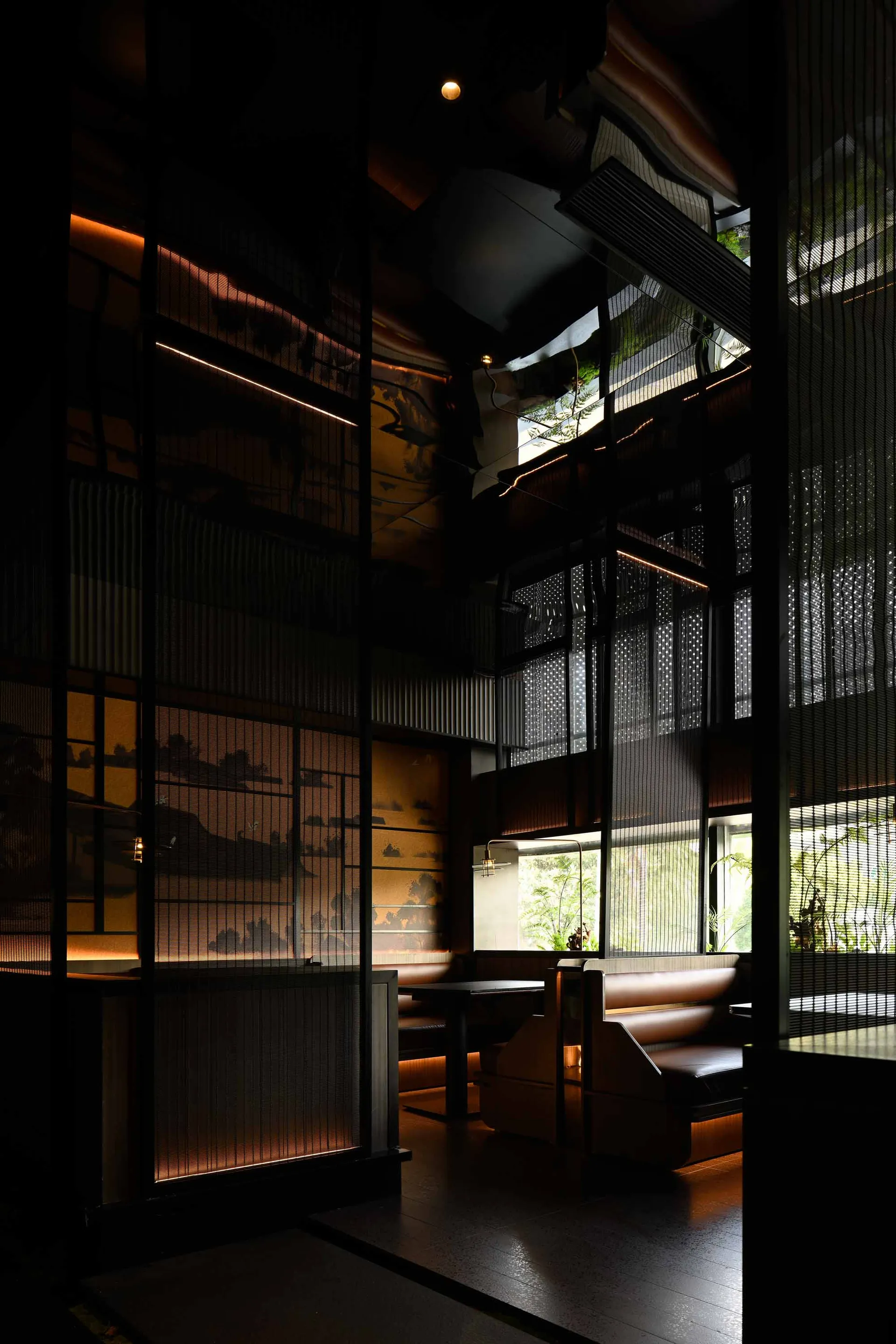 現代工業風餐廳室內,深色牆面搭配金屬欄杆,窗邊自然光營造溫暖氛圍。