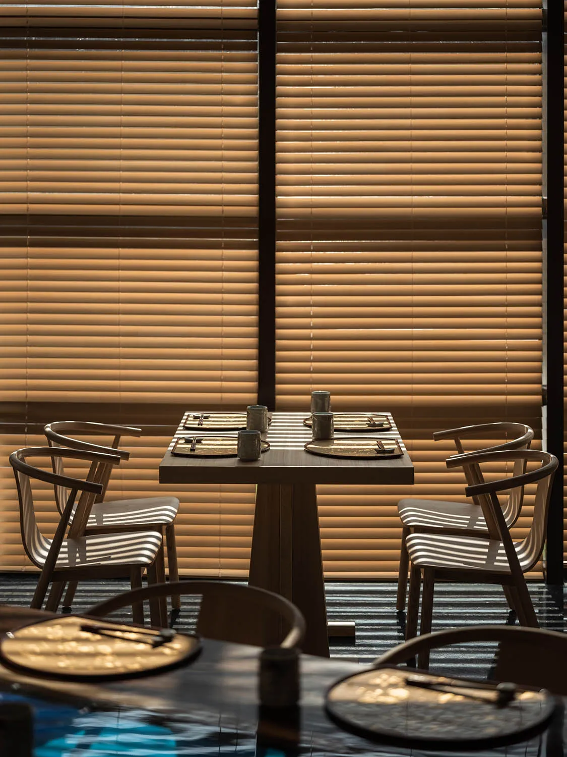 一間現代餐廳空間，擺設木質家具與餐桌餐具。