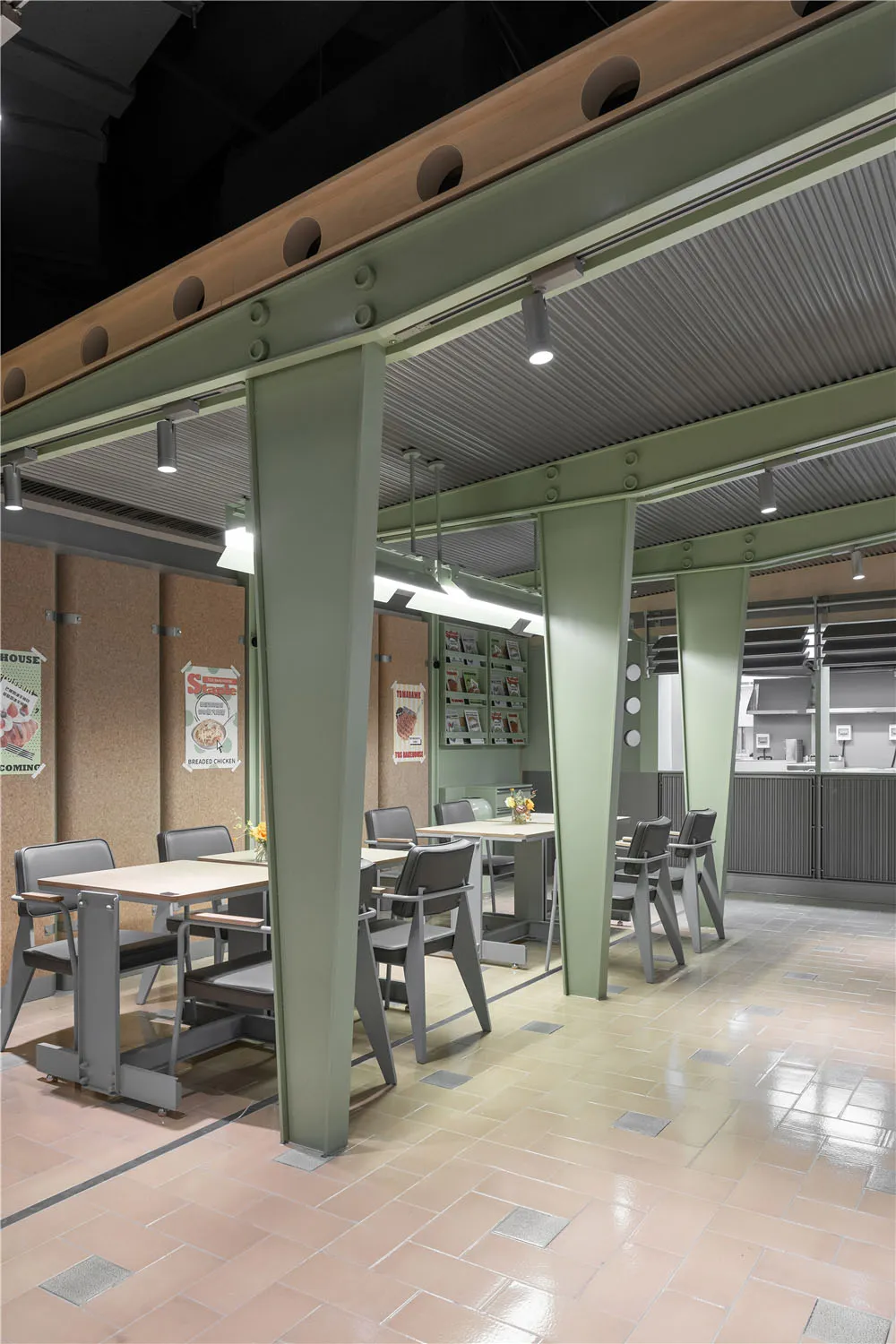 工業風餐廳室內空間,設有金屬柱、軟木板牆面與木製餐桌。