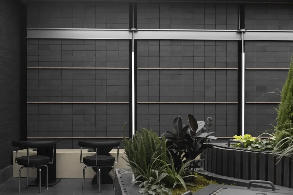 An industrial outdoor patio featuring metal furniture and plants.
