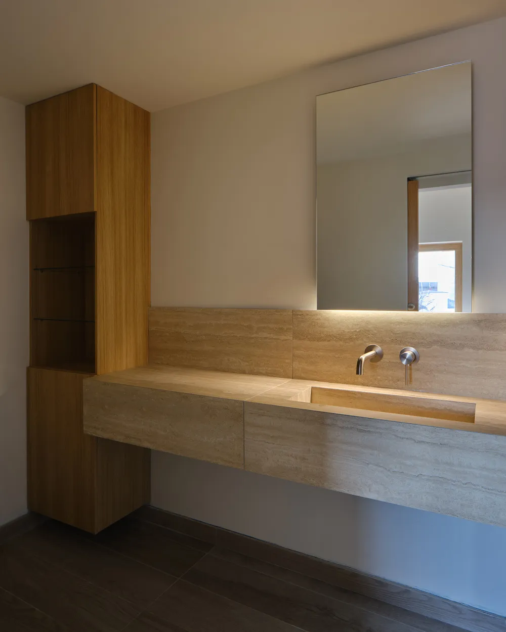 Minimalist bathroom with stone sink and mirror.