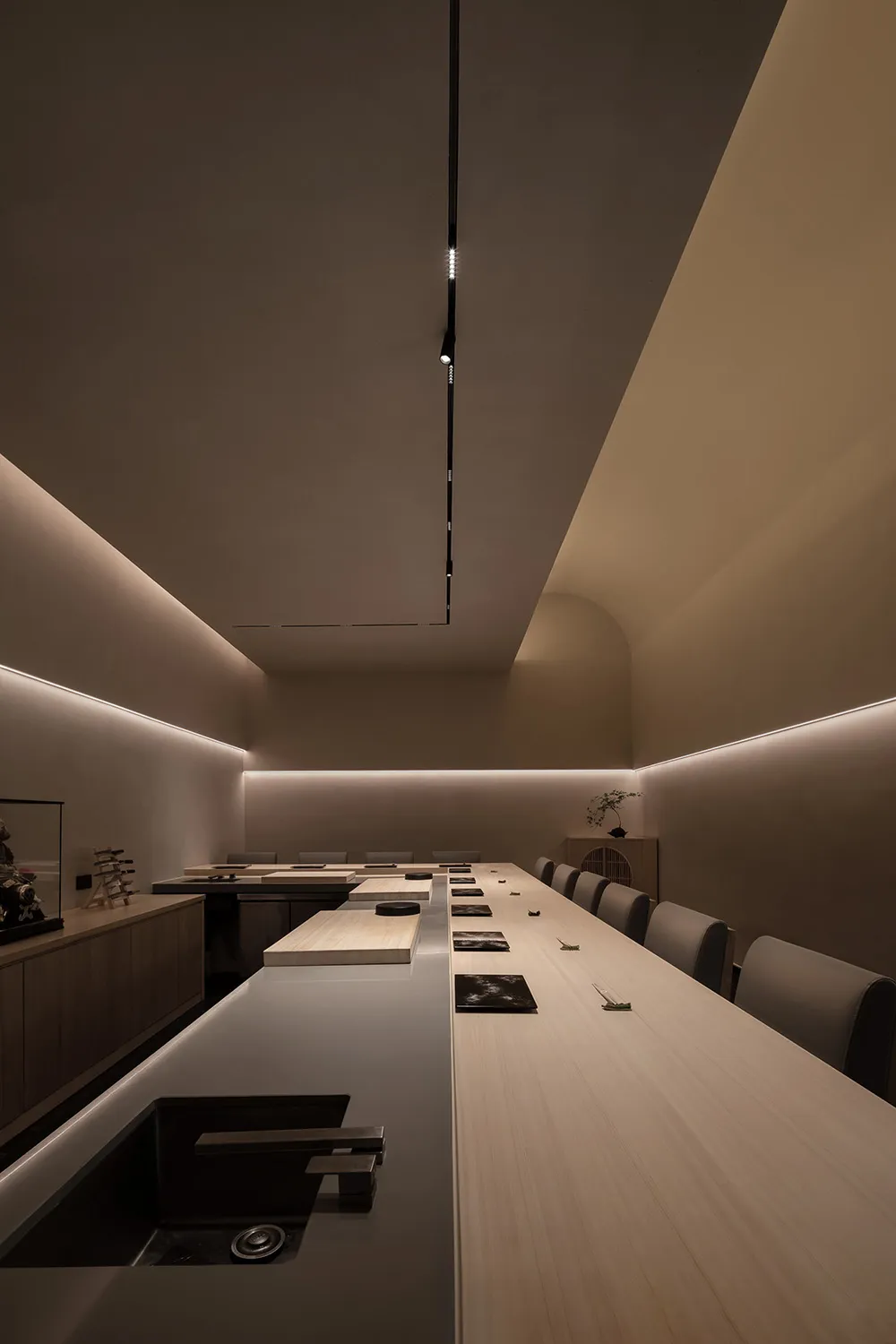 Modern restaurant interior with wooden tables, concrete walls, and minimalist design.
