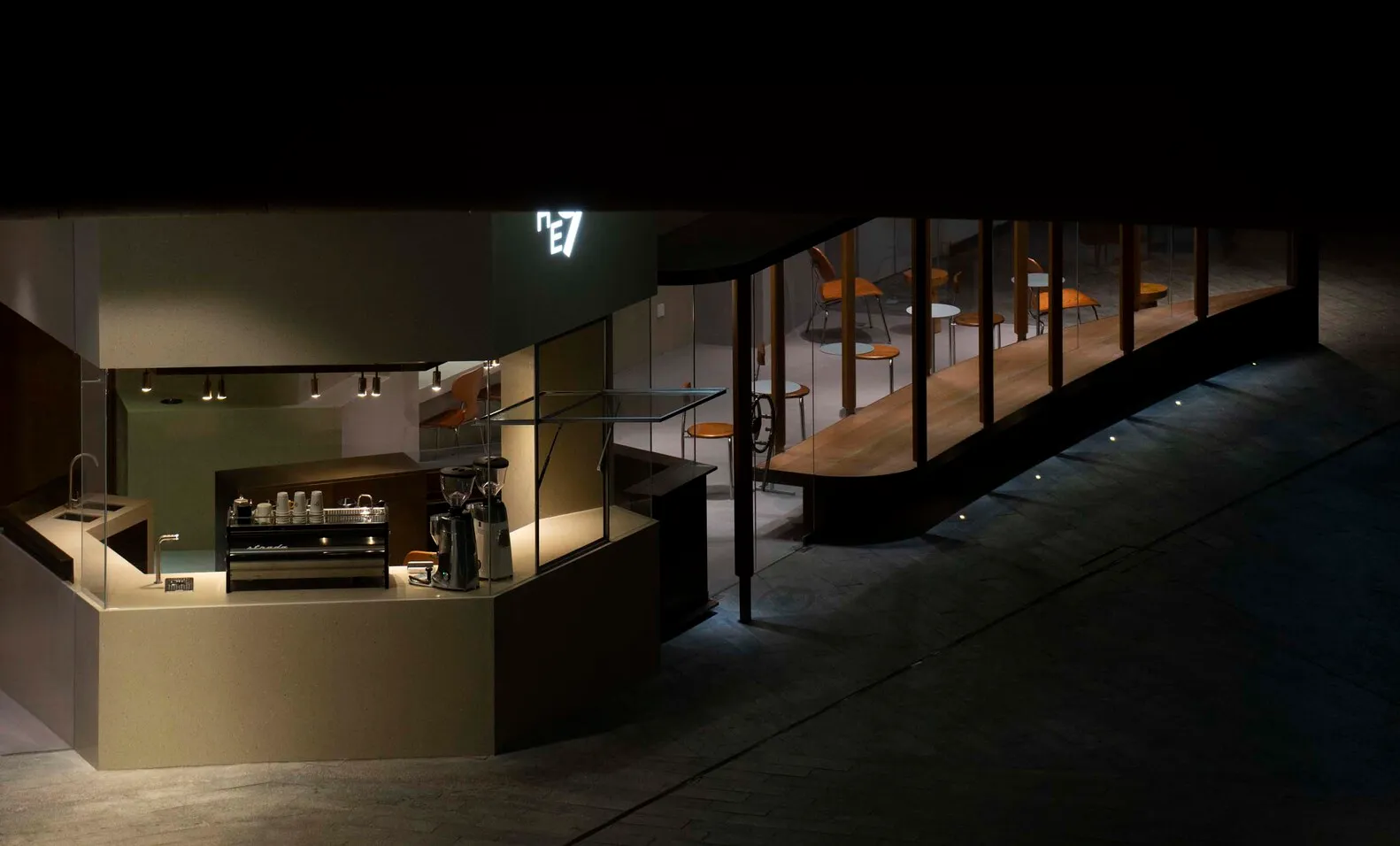 A minimalist coffee shop with a glass counter and modern design elements.