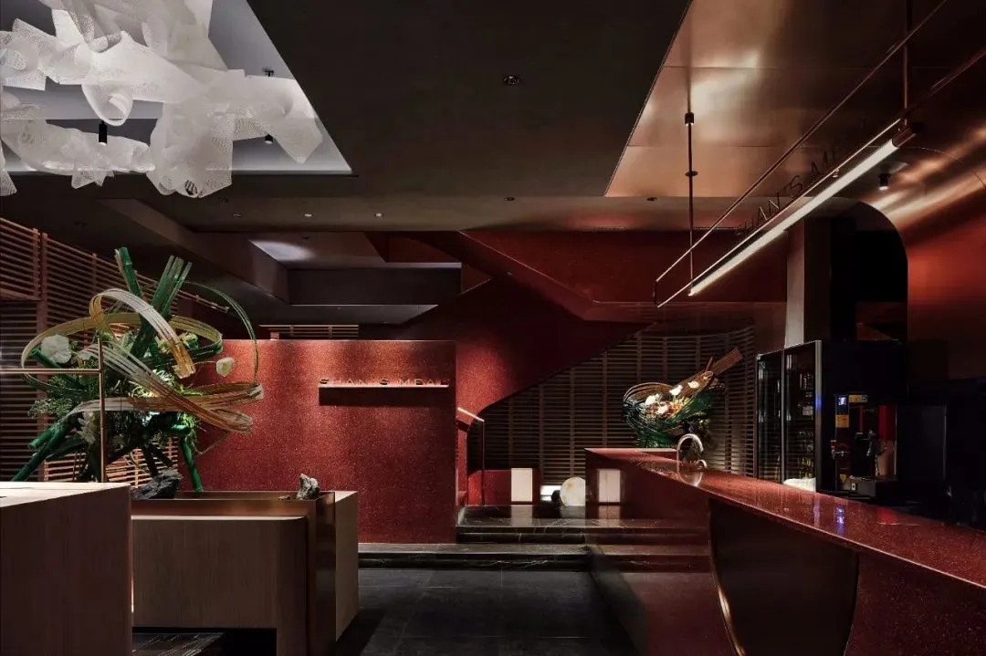 A modern restaurant entrance with red brick walls and metallic accents.
