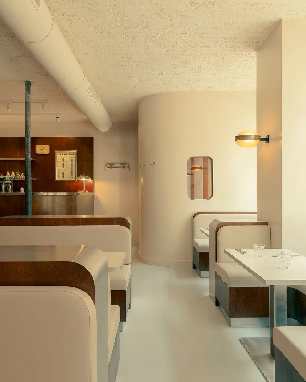 Industrial-style restaurant interior with concrete walls, metal decor, and minimalistic design.