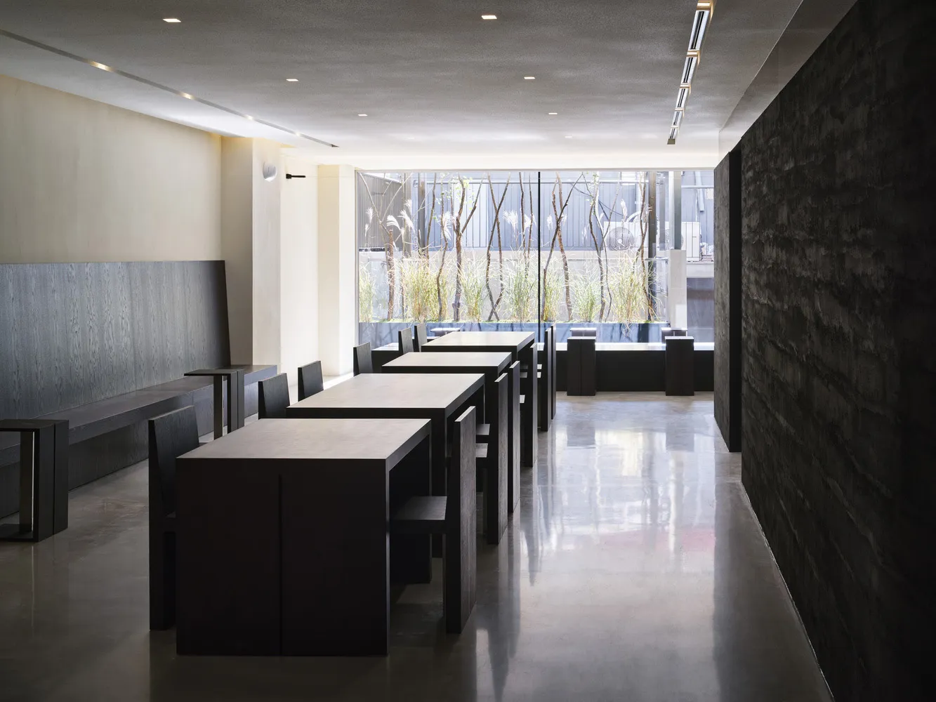 Sleek, modern restaurant interior with concrete floors and minimalist design.