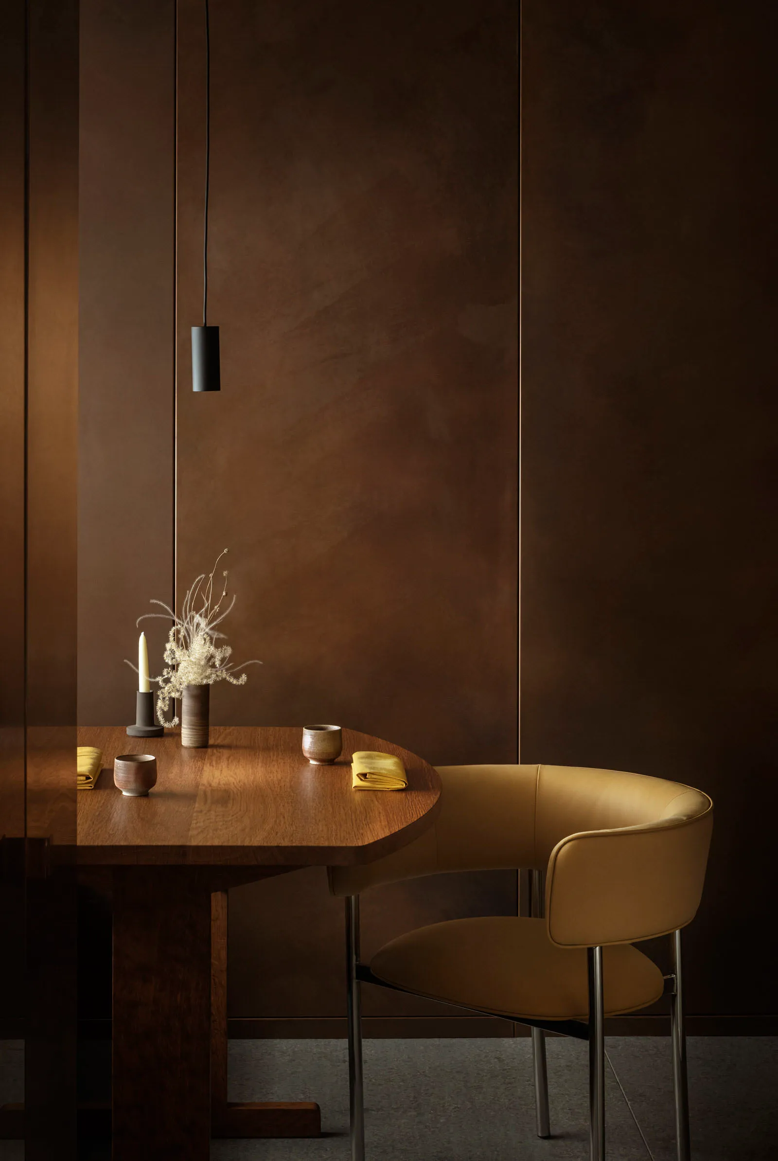 A modern dining room with a wooden table and leather chair.